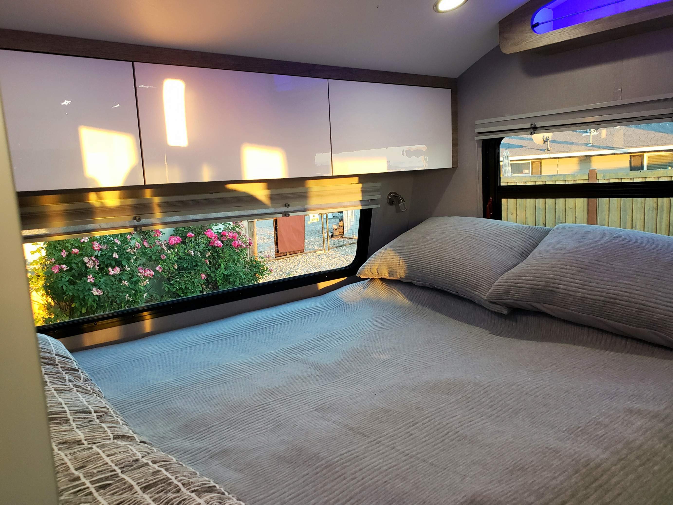 Bright RV rental bedroom featuring a comfortable bed, sleek cabinets, and a scenic window view with natural light.. InTech RV InTech RV Trailer 2021