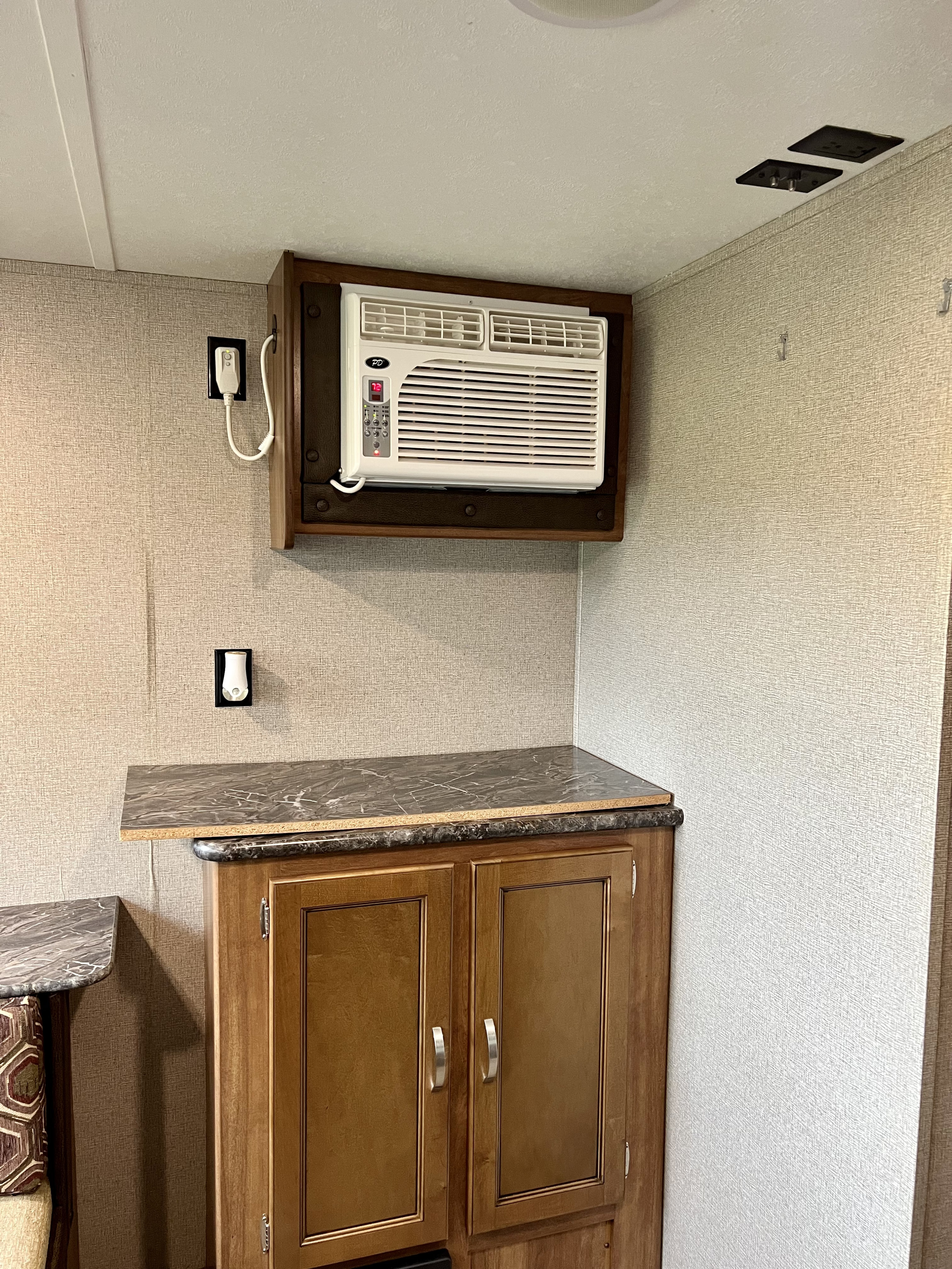 RV rental: Wall-mounted AC unit, kitchenette counter, and storage cabinets in a compact interior.. Keystone RV Springdale 2017