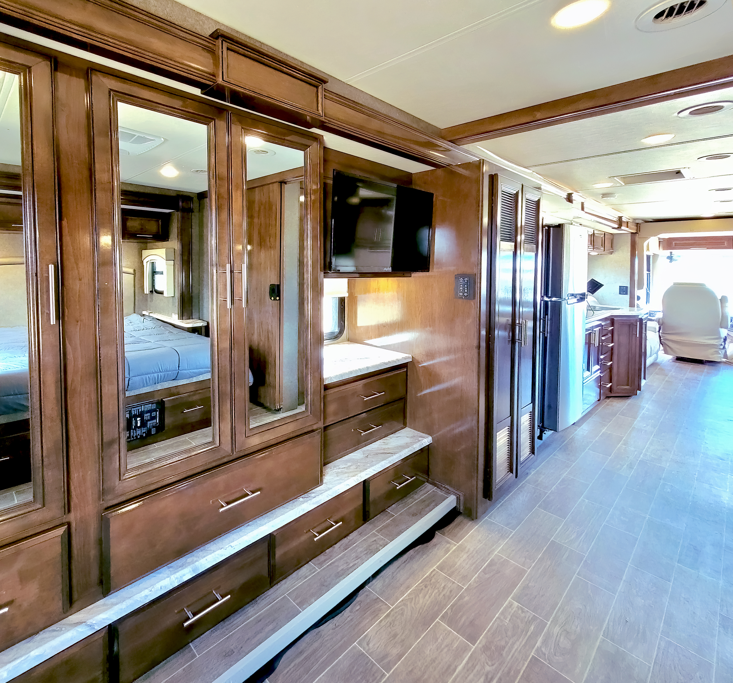 Spacious RV rental interior featuring a bedroom with mirrored closets, kitchen area, and forward living space. Ideal for your next adventure.. Thor Motor Coach Miramar 2020