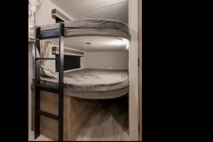 Spacious RV rental bunk beds, perfect for family sleeping. This modern RV interior features comfy mattresses and a ladder.. Grand Design Imagine 2022