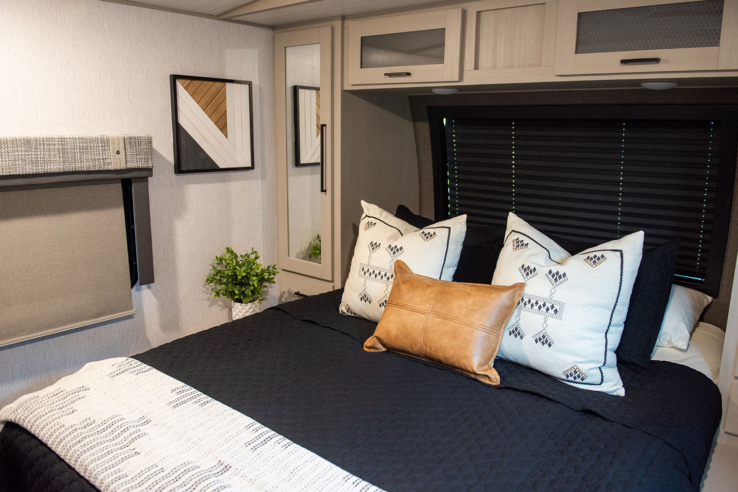The master bedroom includes a queen bed, a separate AC unit, 42-inch TV, storage space, and plenty of outlets for charging phones and devices.. Forest River Wildwood Heritage Glen 2023
