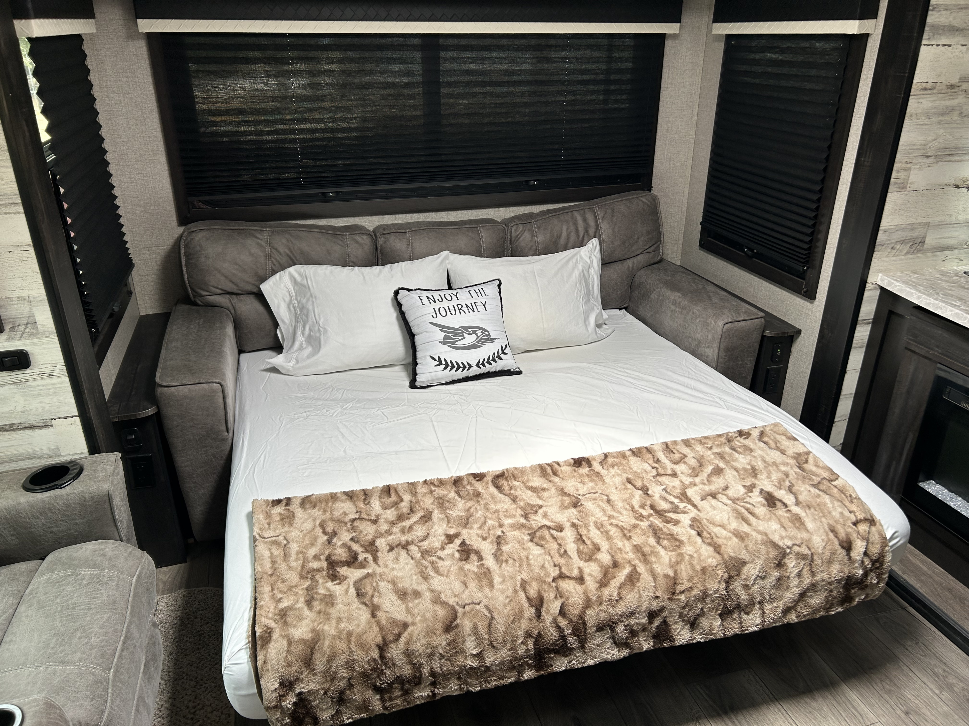 Comfortable RV rental sofa bed setup, ready with pillows and a cozy throw blanket for a relaxing stay.. Jayco White Hawk 2020
