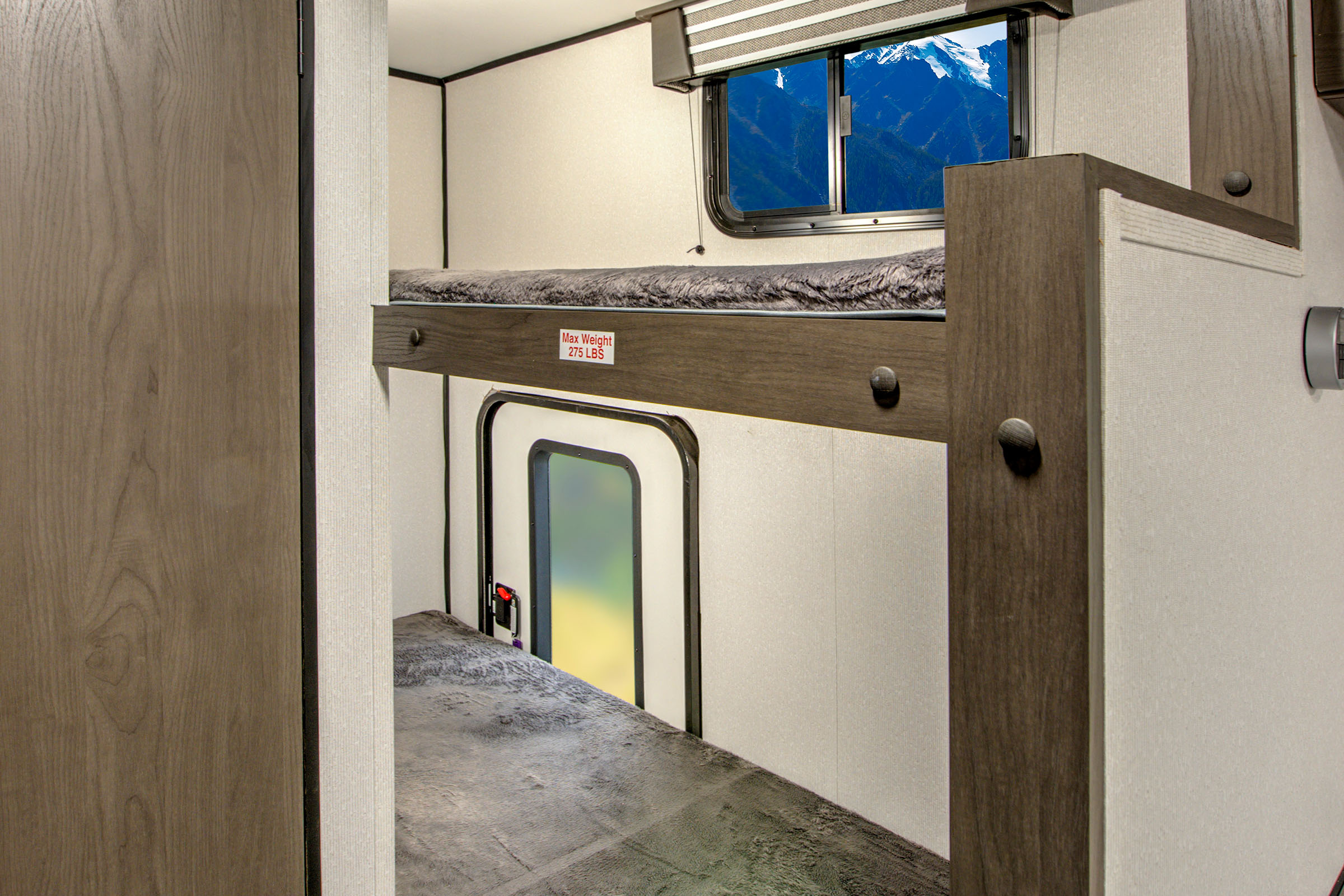 Inside this RV rental, find compact bunk beds. The top bunk shows a 275 lb limit, with a scenic mountain window view.. Heartland RVs Mallard Pathfinder 2021