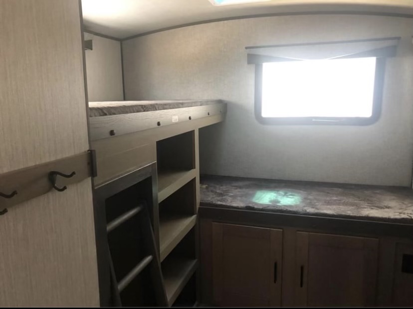 Experience comfort in this rv rental bunkhouse: features bunk beds, built-in storage shelves, and a bright window.. Cruiser Rv Corp Twilight 2021