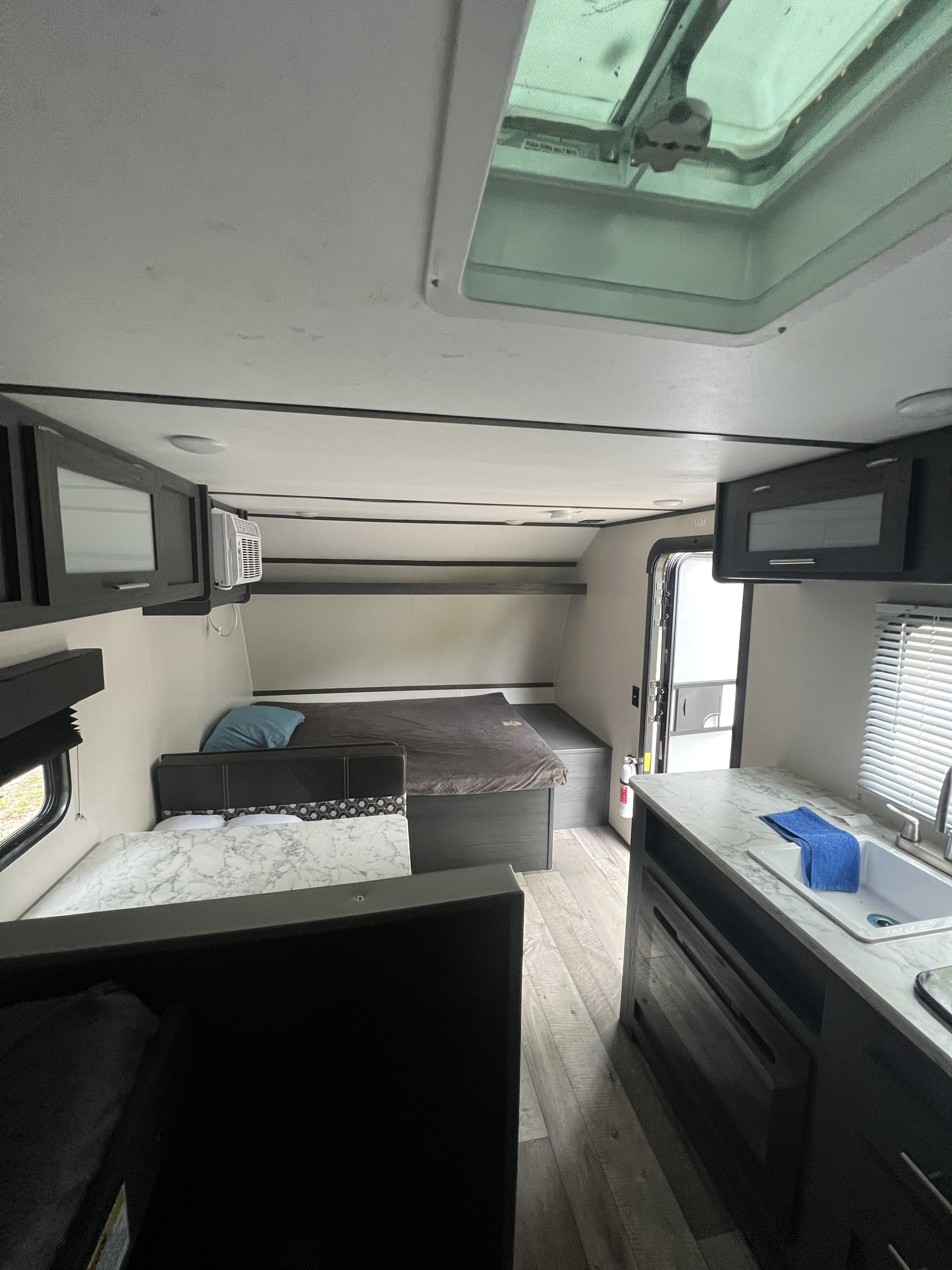 Cozy RV rental interior with two beds, compact kitchen, and skylight for comfortable travel.. Coachmen Aspen trail 2022