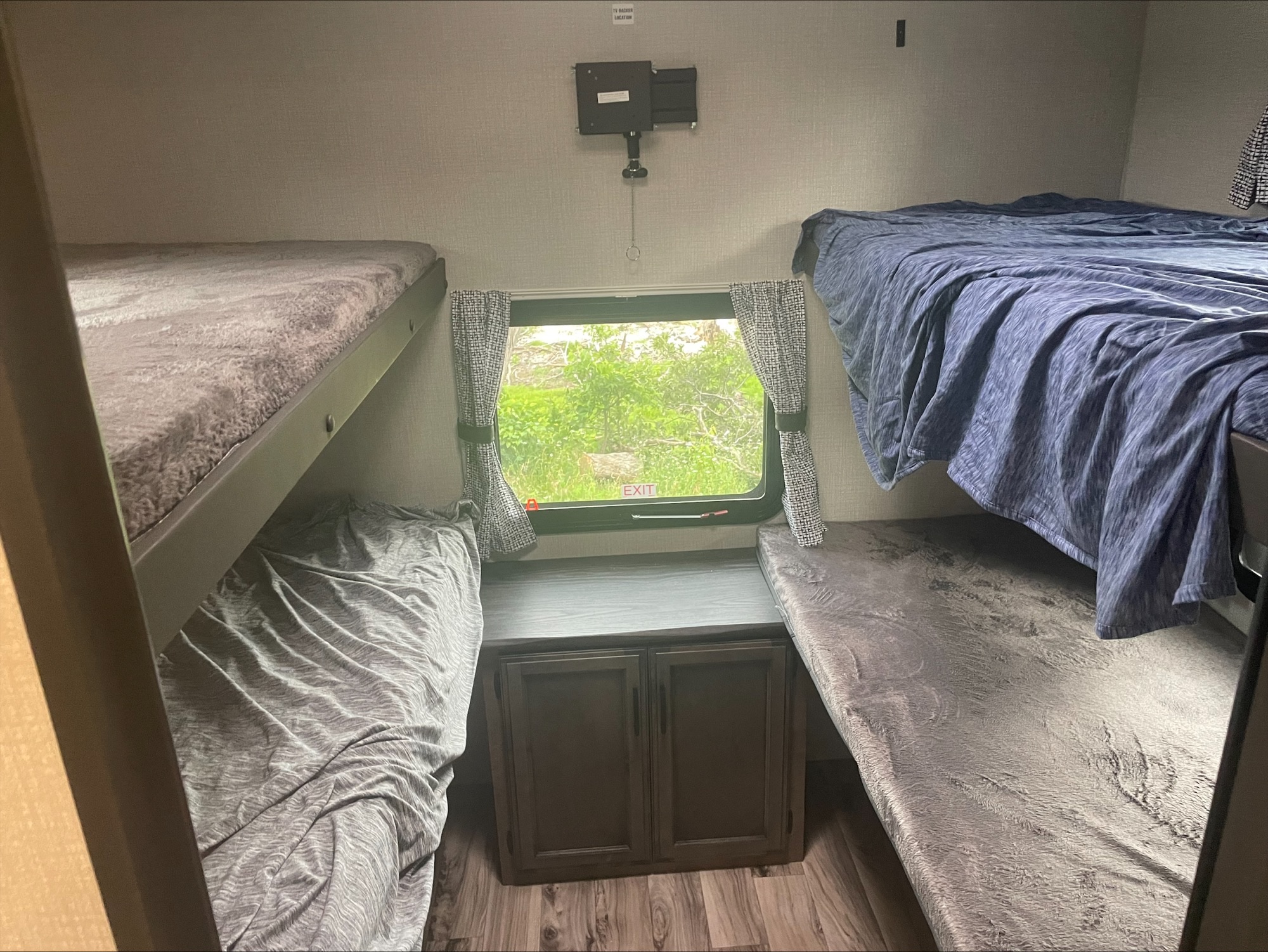 Cozy RV rental bunk area with four bunk beds, a window, and central storage, perfect for families.. Sport Trek Sport Trek Trailer 2022