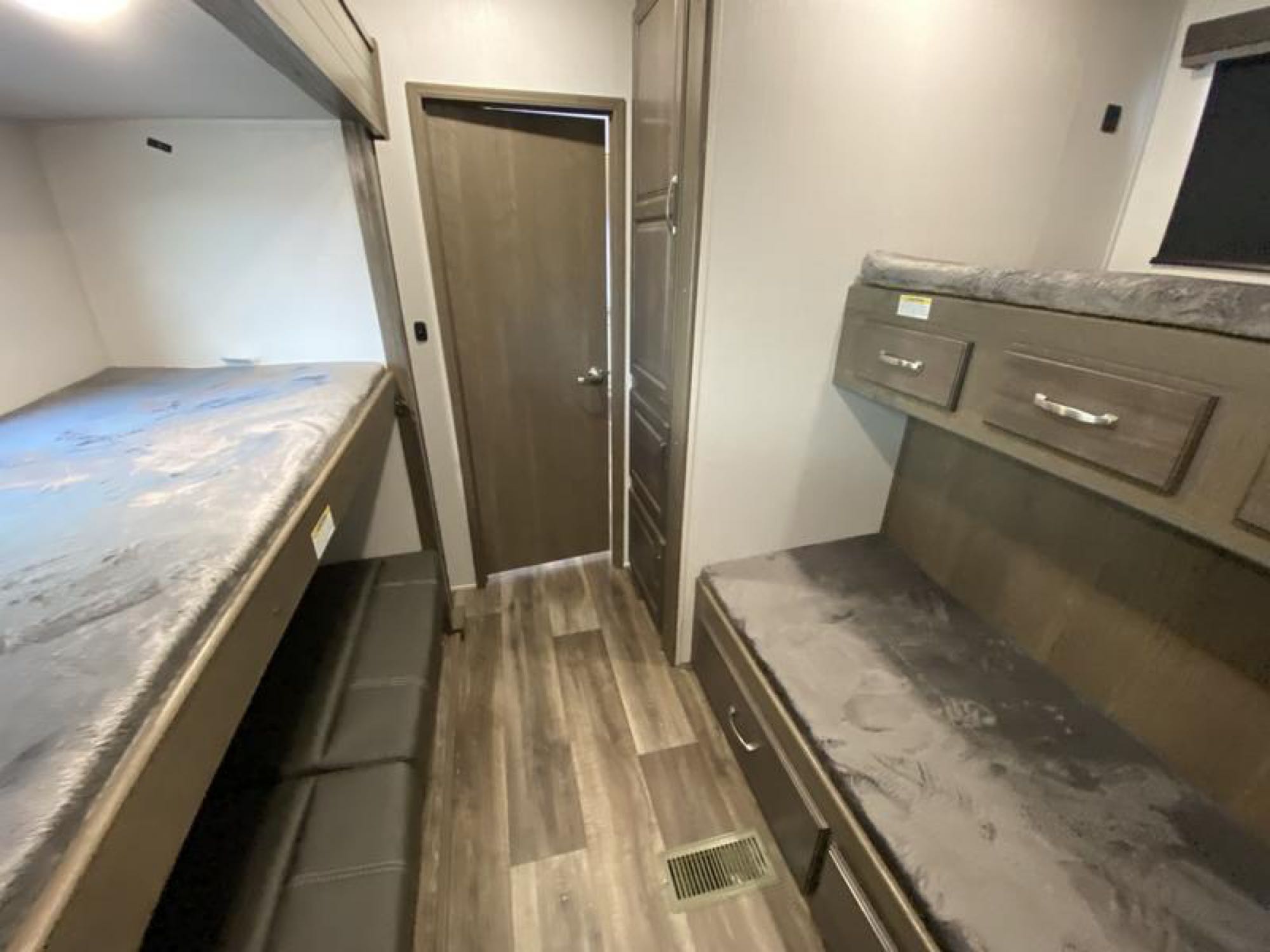 RV rental bunkhouse layout with two sets of bunk beds, hallway, bathroom door, and built-in storage.. Keystone RV Cougar 32BHS 2021
