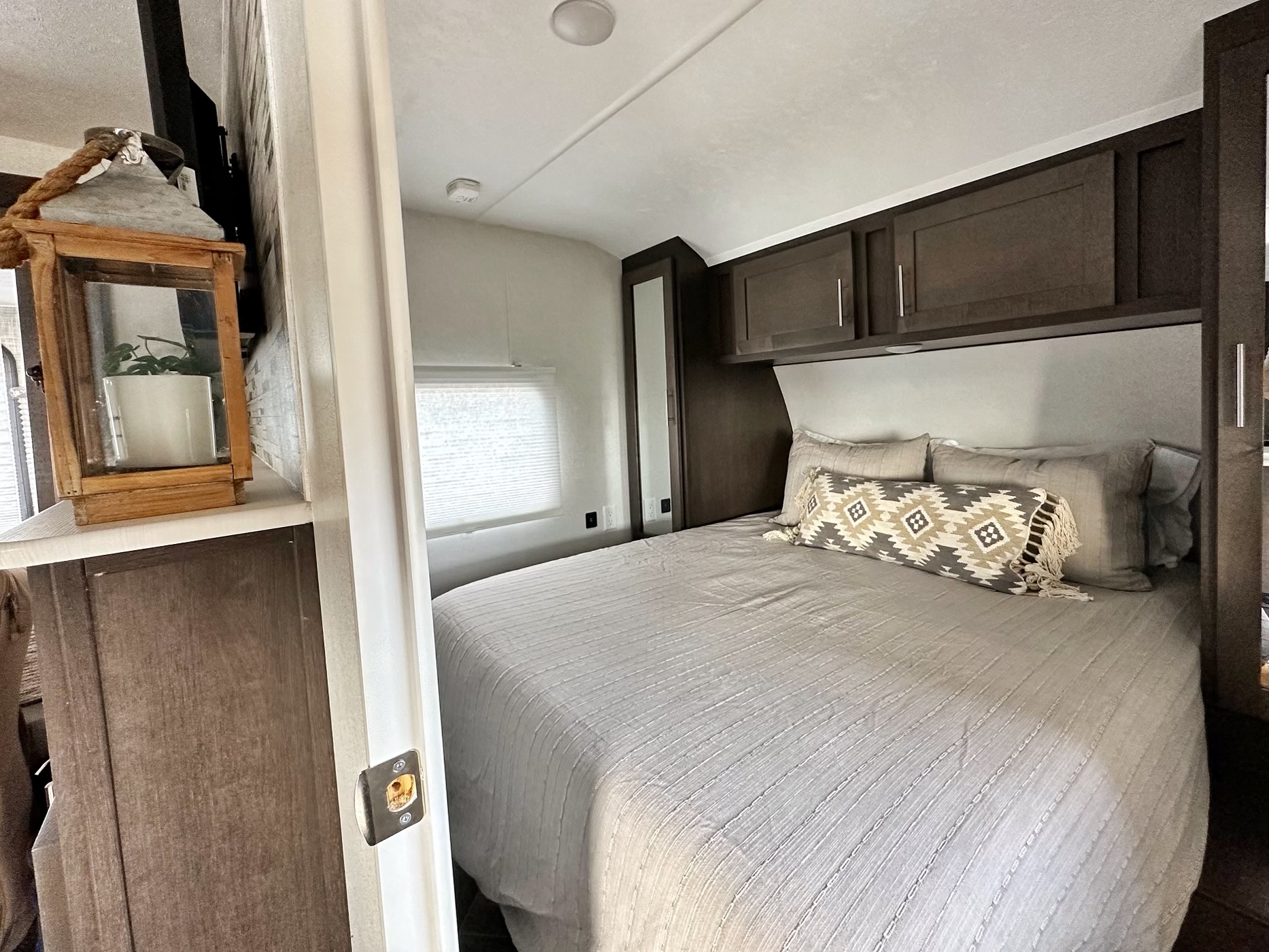 Cozy RV rental bedroom featuring a comfy bed, overhead storage, and light decor. Ideal for your next adventure.. Forest River Evo 2020