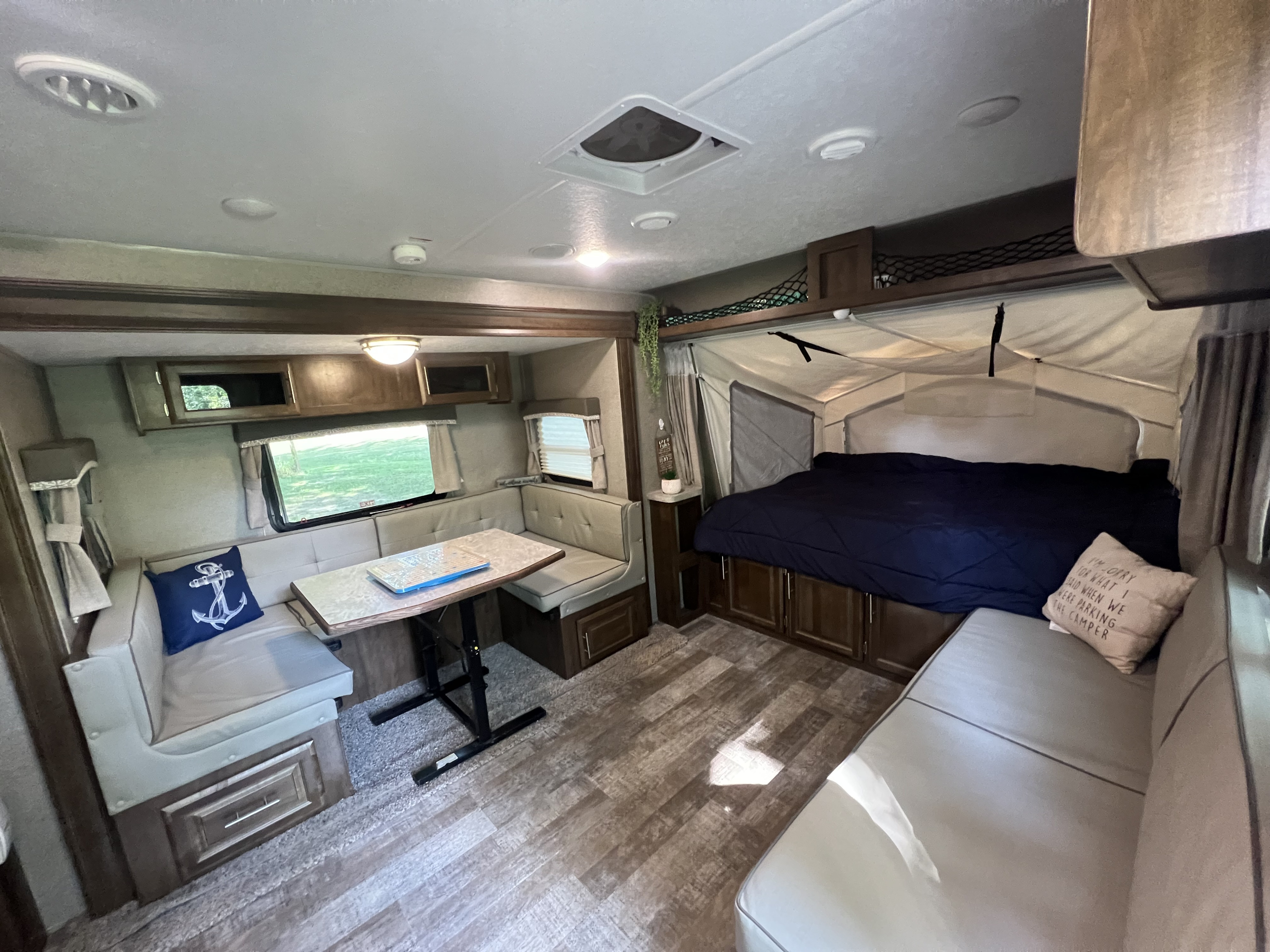 Explore this inviting rv rental interior, showcasing a cozy pop-out bed, dinette, and sofa area for comfortable adventures.. Forest River Rockwood Roo 2019
