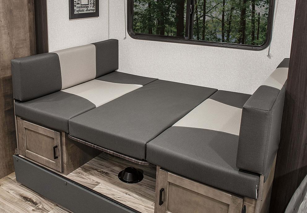 This RV rental features a comfortable convertible dinette with two-tone cushions, under-seat storage, and a scenic window view.. Sonic Lite 2023