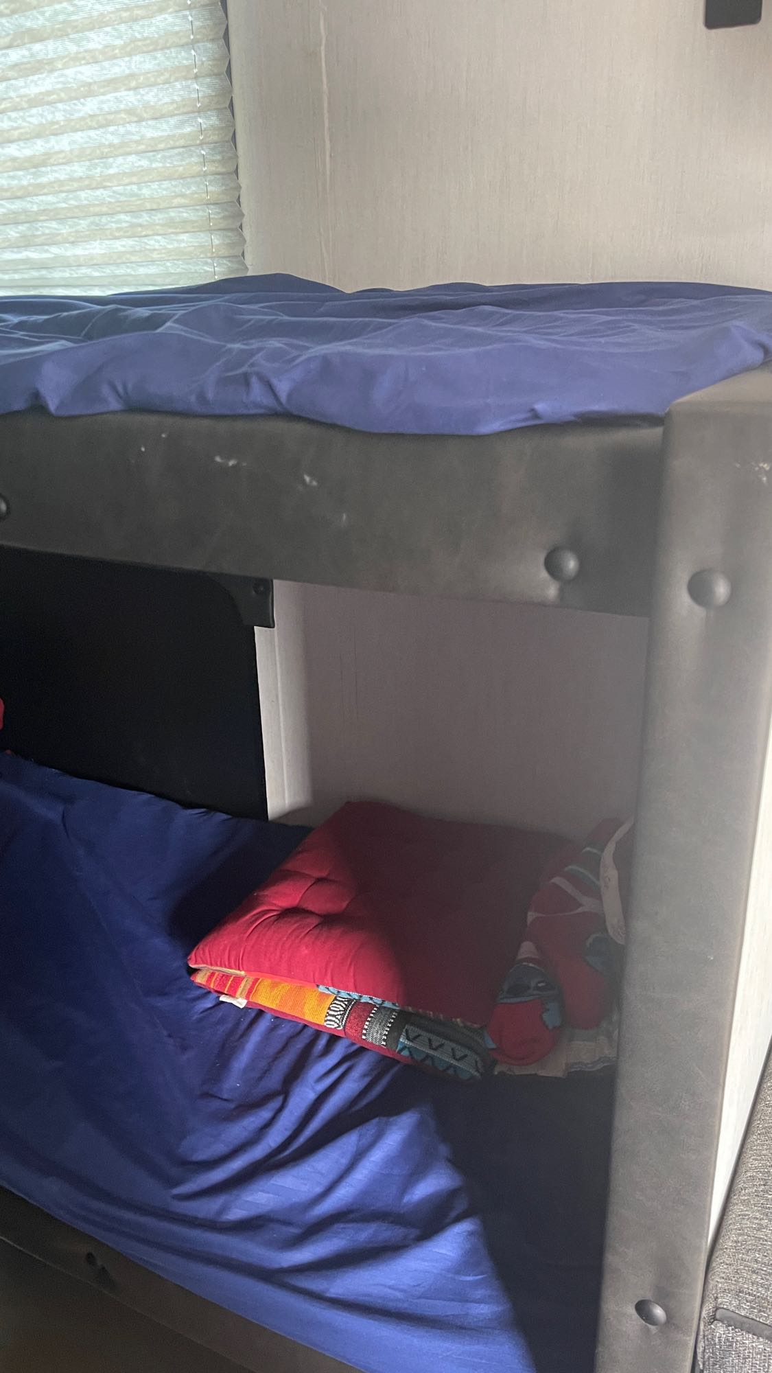 RV rental bunk beds: top with blue duvet, bottom with blue sheet, red cushion & blanket. Compact sleeping.. Forest River Wolf Pup 2022