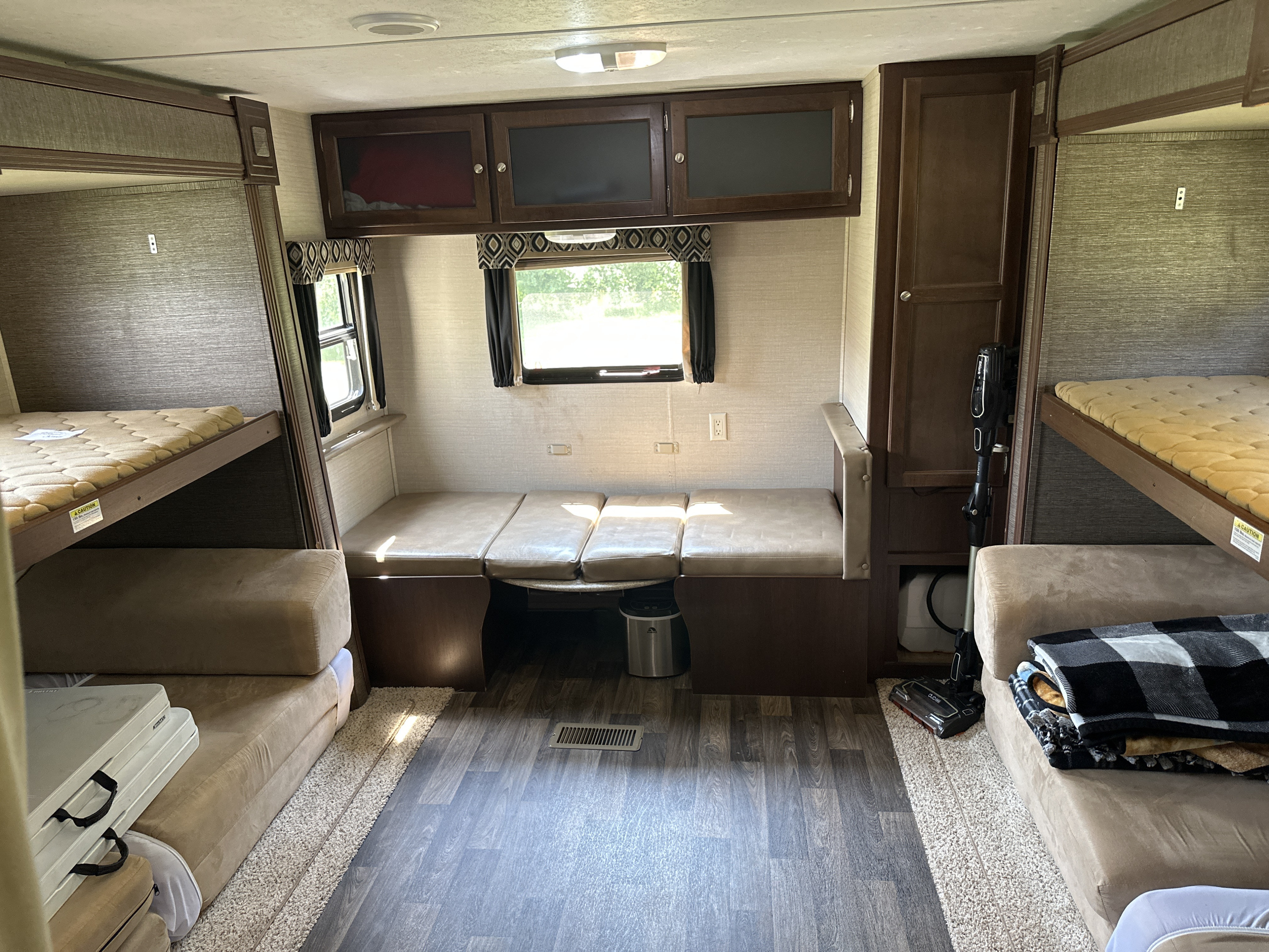 Inside an RV rental: features include four bunk beds, a dinette area, and ample overhead storage for travel comfort.. Keystone RV Bullet Ultra Lite 2015
