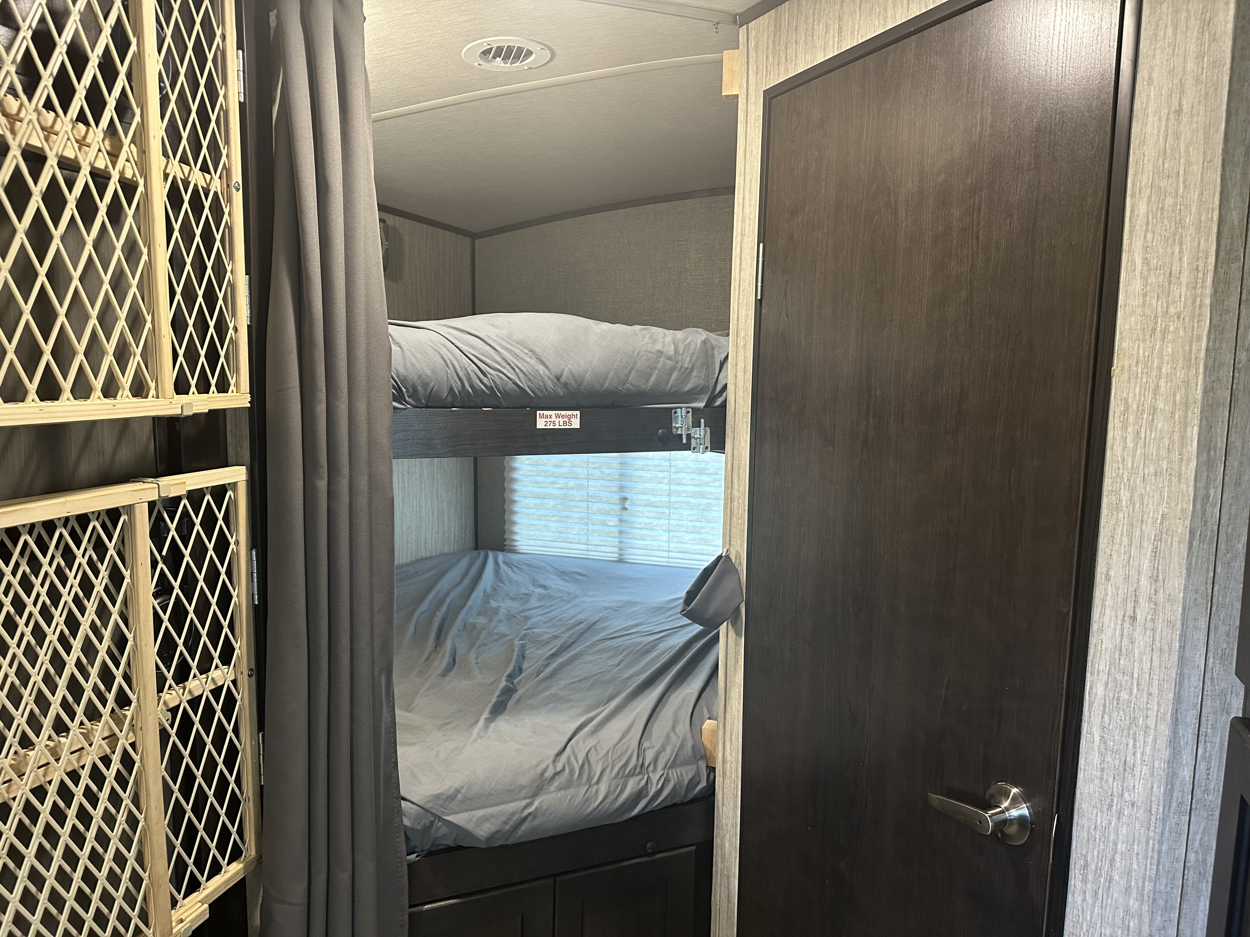 Cozy RV rental sleeping area featuring bunk beds, a safety gate, and privacy curtain.. Cruiser RV Shadow Cruiser 2020
