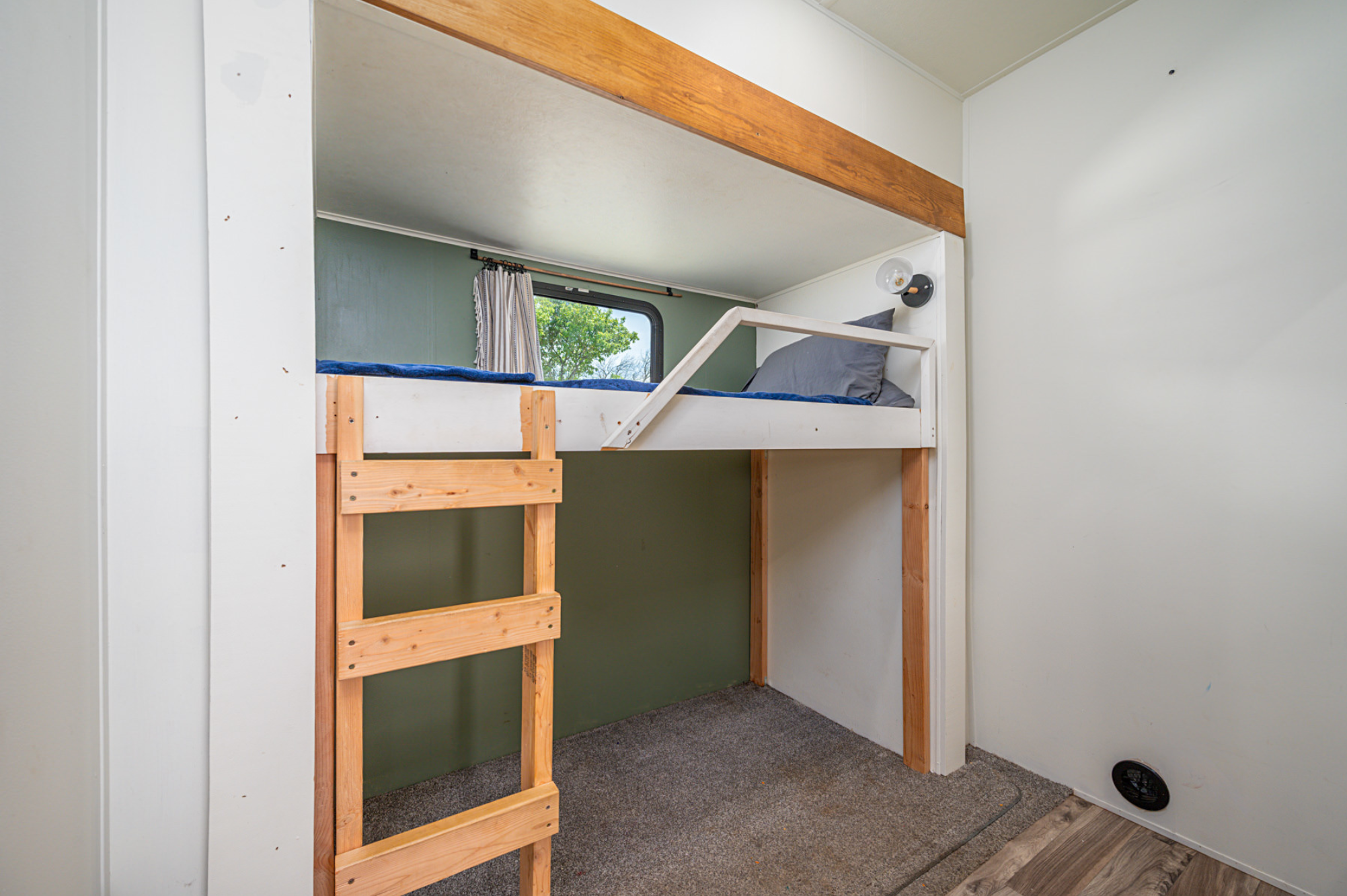 Functional RV rental interior featuring cozy bunk beds with a ladder, window view, and reading light.. Forest River Wildwood Heritage Glen Lite 2018