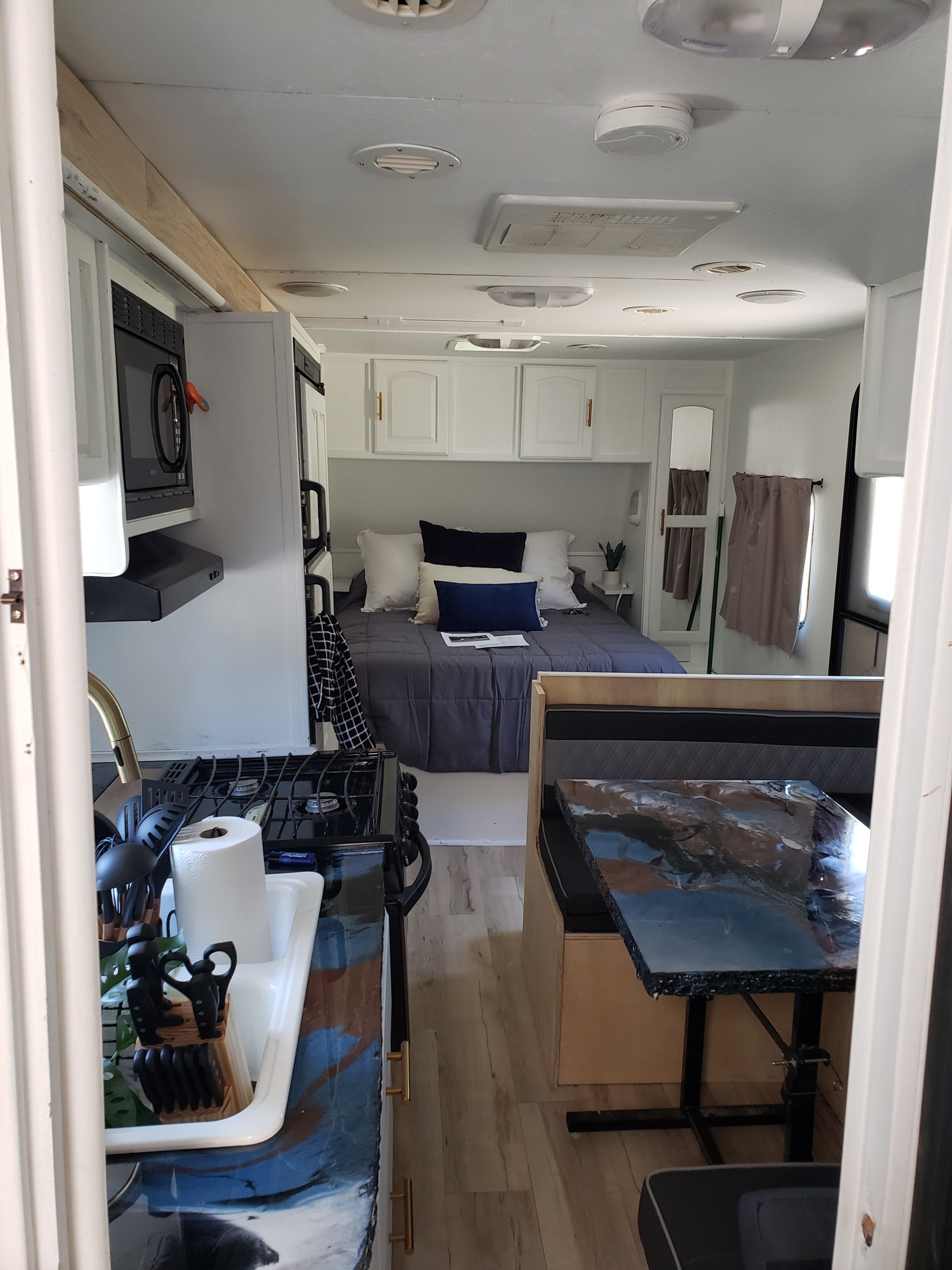 Stylish RV rental interior with a fully equipped kitchen, comfortable bedroom, and spacious dining nook.. Forest River Surveyor Sport 2012