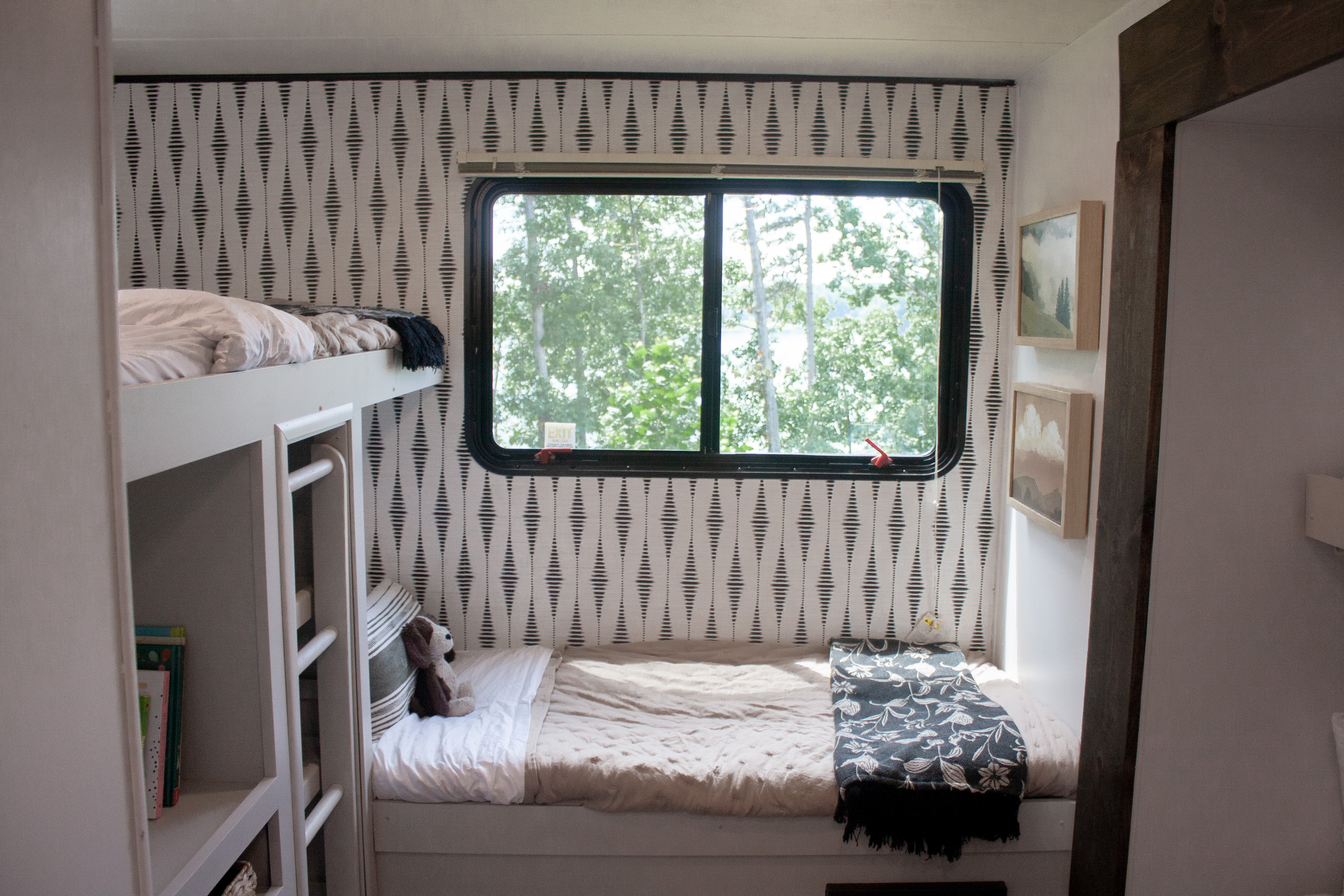 Cozy RV rental interior with patterned wall, window view, and built-in bunk beds.. Heartland RVs Pioneer 2020