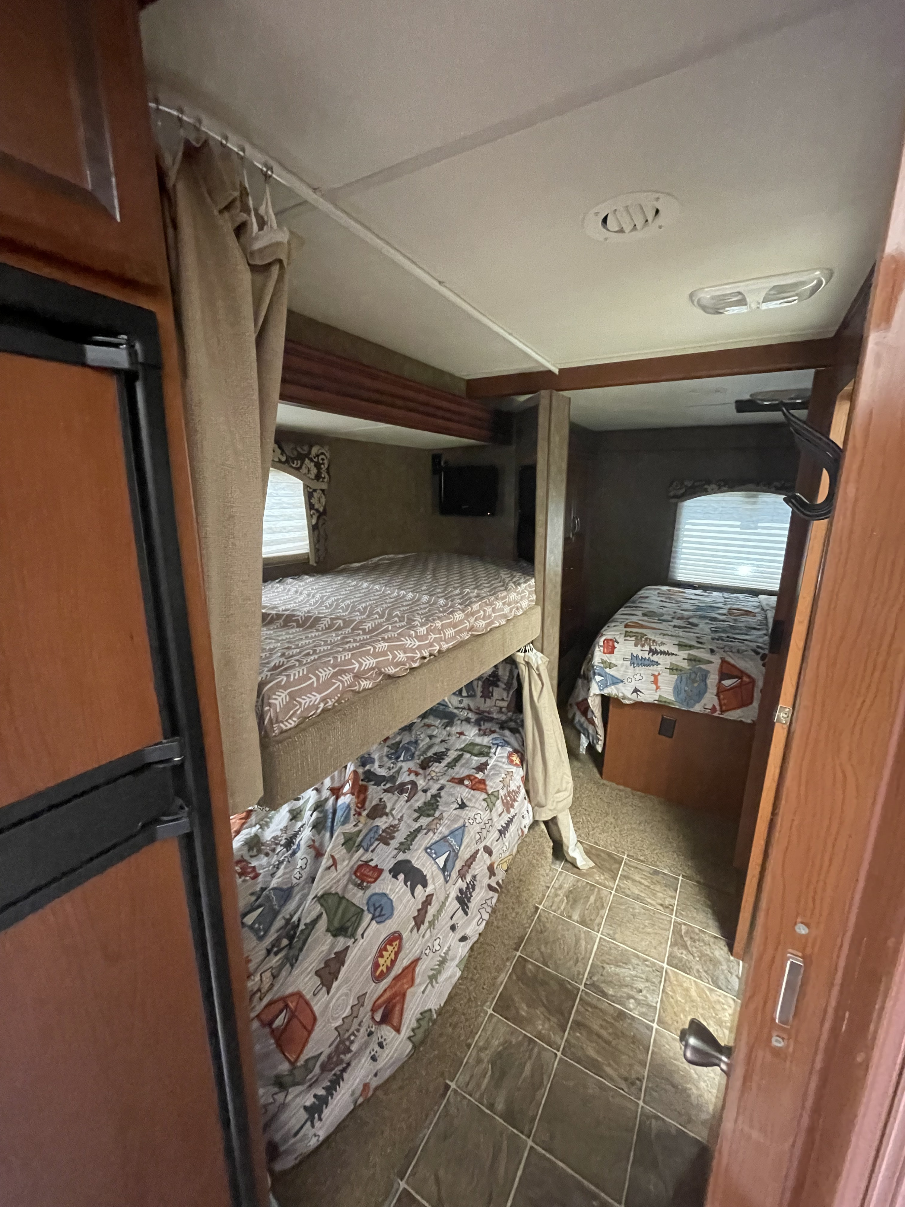 Inside an RV rental: view of comfortable bunk beds & a separate bed area, perfect for a family road trip.. Thor Chateau 2013