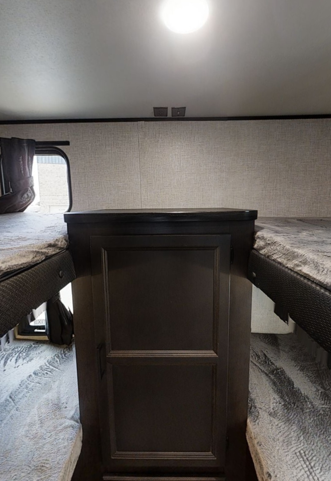 RV rental bunk beds flank a central dark wood storage cabinet, offering cozy sleeping & storage in this camper.. Jayco Jay Flight 2023