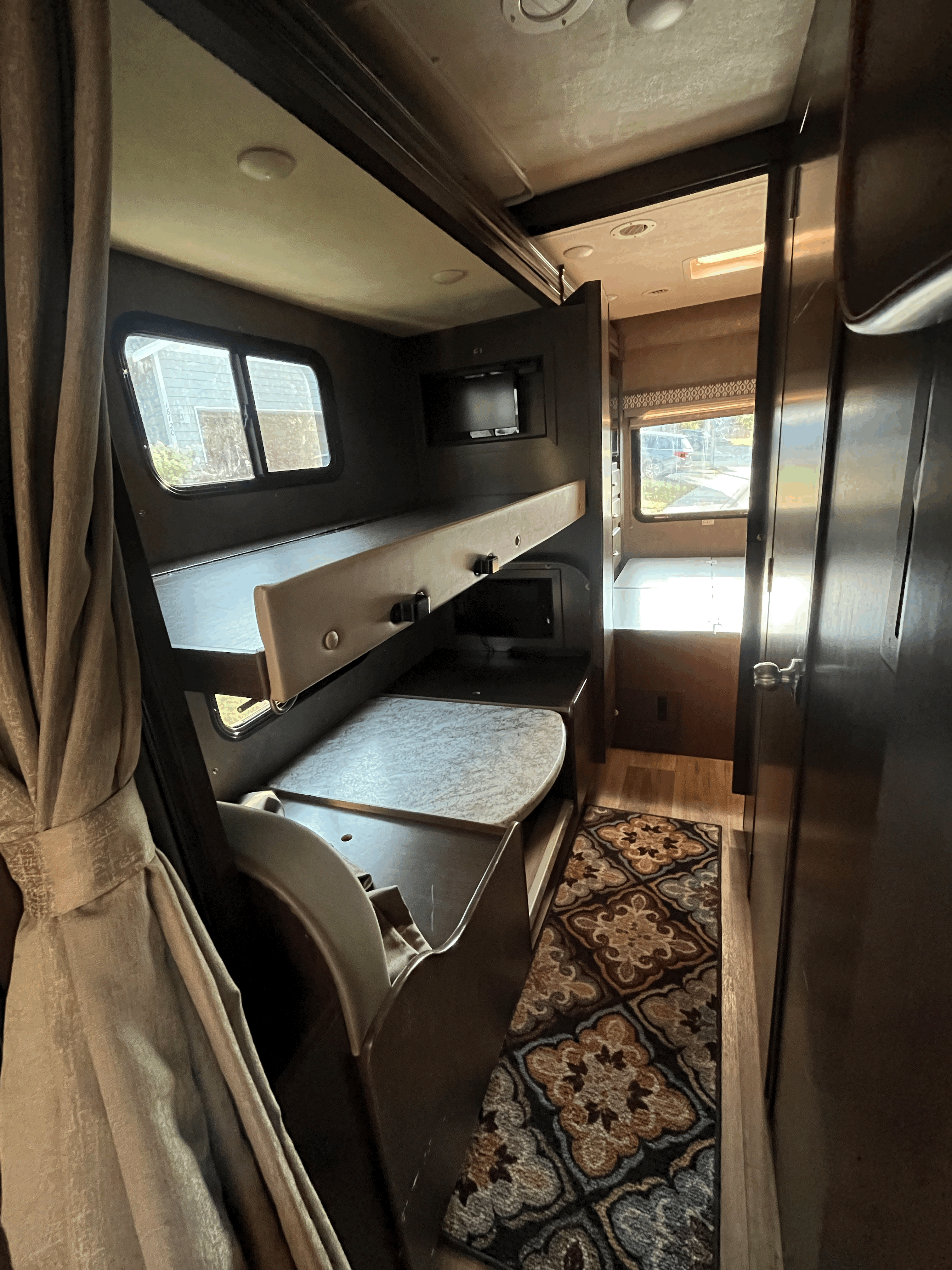 Inside this RV rental: cozy bunk beds, a convenient dinette, and TVs, offering a comfortable travel space.. Thor Freedom Elite 2020