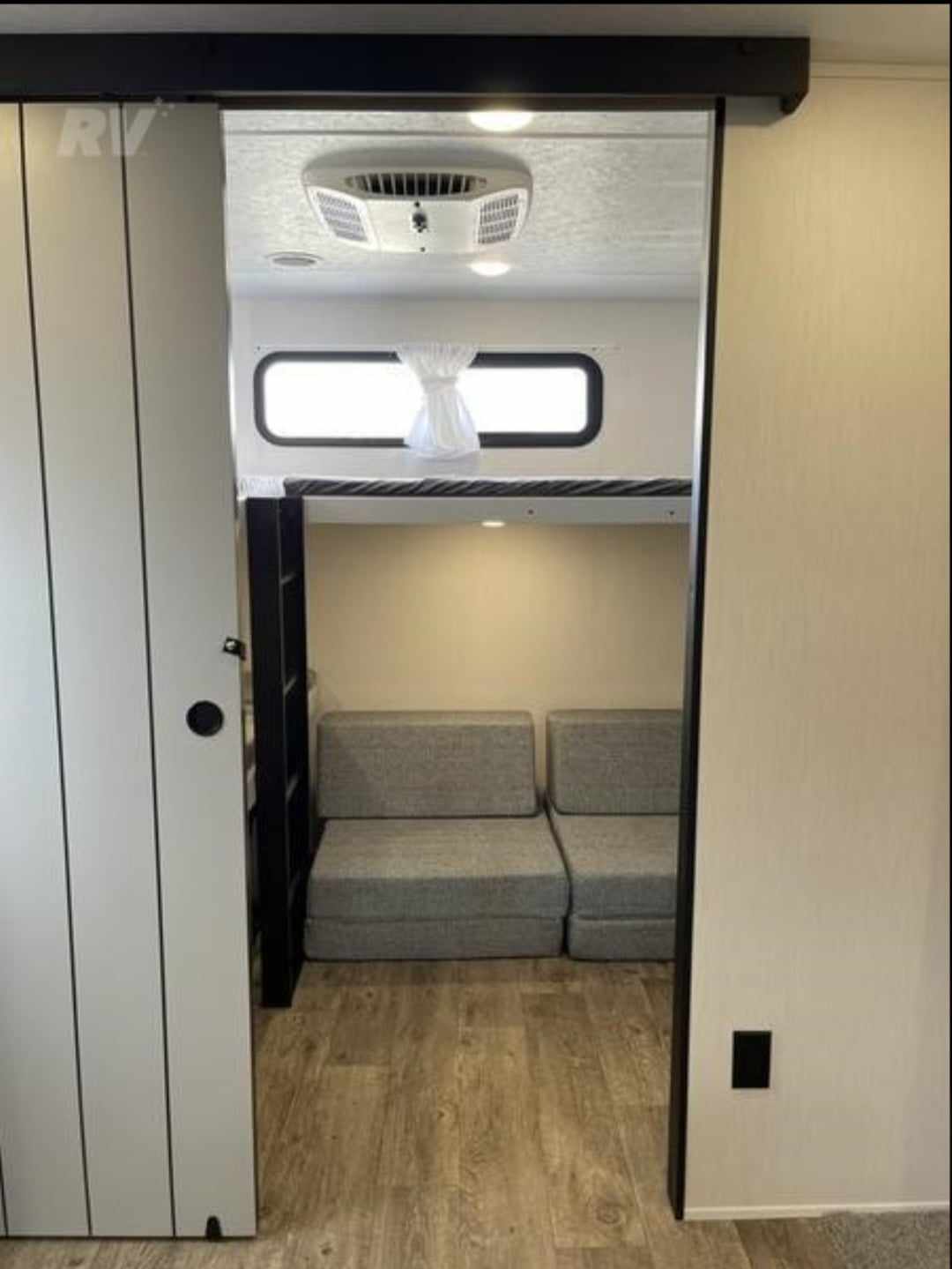 View into a cozy RV rental bunkhouse with a top bunk, AC, windows, and versatile modular floor seating. Ideal for guests.. Forest River Vibe 2022