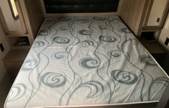 Comfortable RV rental bedroom with patterned mattress, spacious bed, and convenient nightstands. Ideal for your next adventure!. Grand Design Transcend Xplor 2020