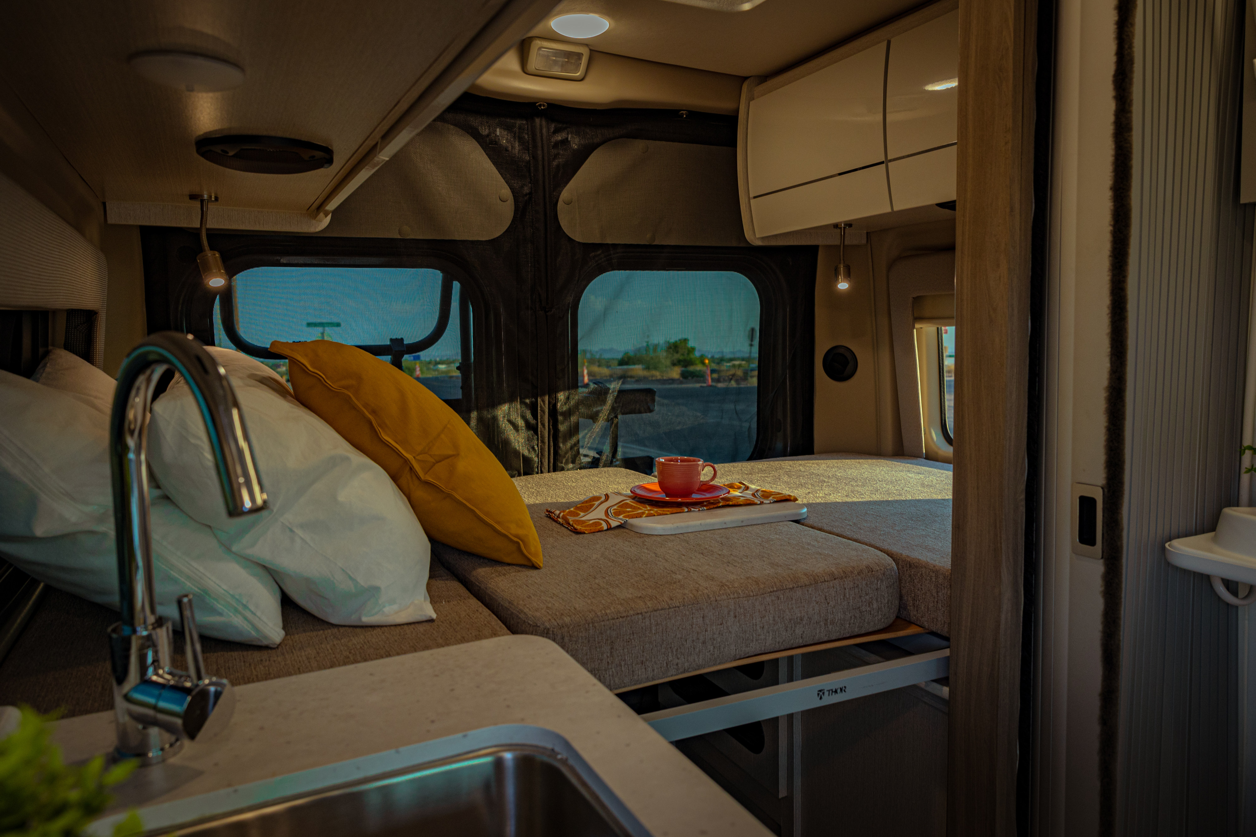 Thor RV rental: a comfy bed, functional sink, and spacious windows create a serene mobile. Thor Rize 2023