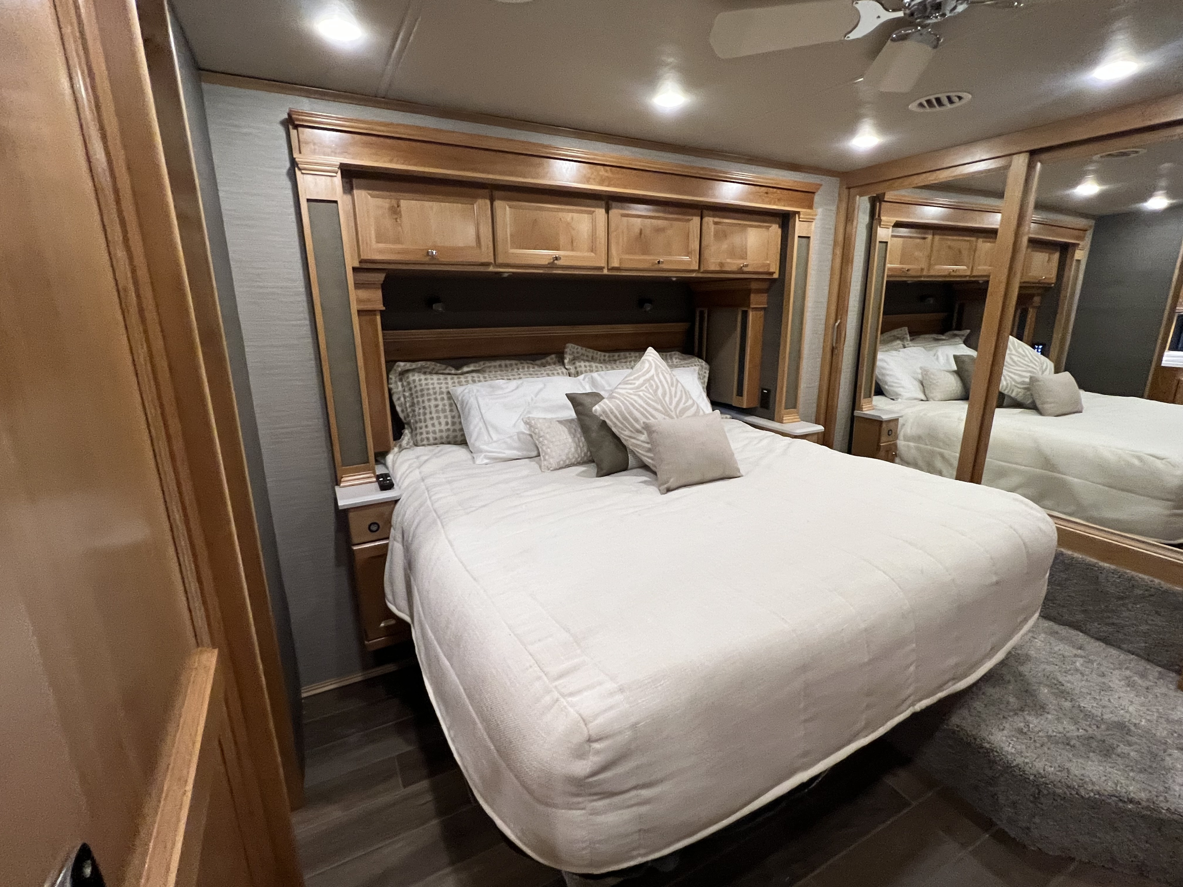 Cozy RV rental bedroom with a large bed, built-in wooden cabinets, nightstands, and a mirrored closet, offering comfort for travel.. Allegro Allegro Red 360 2022