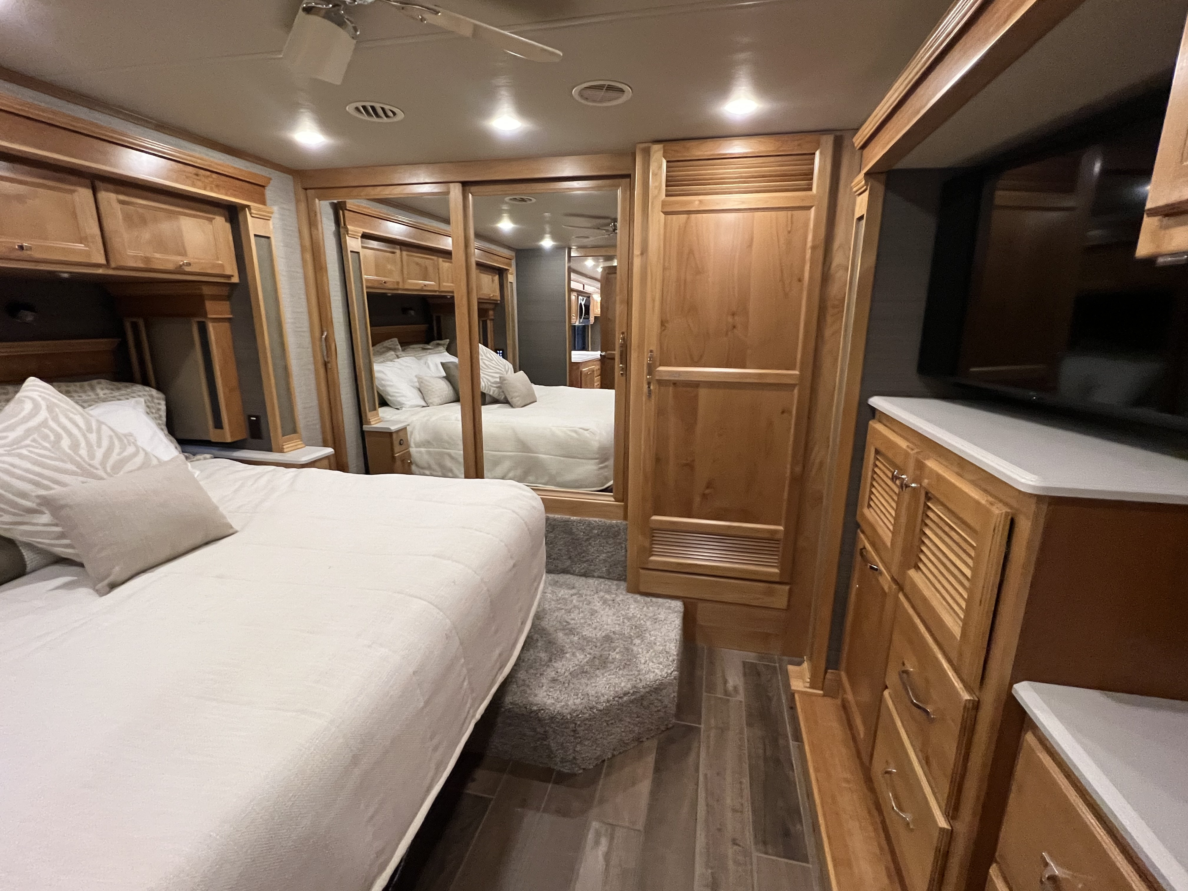 Experience comfort in this RV bedroom. Features plush bed, mirrored closet, TV, and storage for your rv rental.. Allegro Allegro Red 360 2022