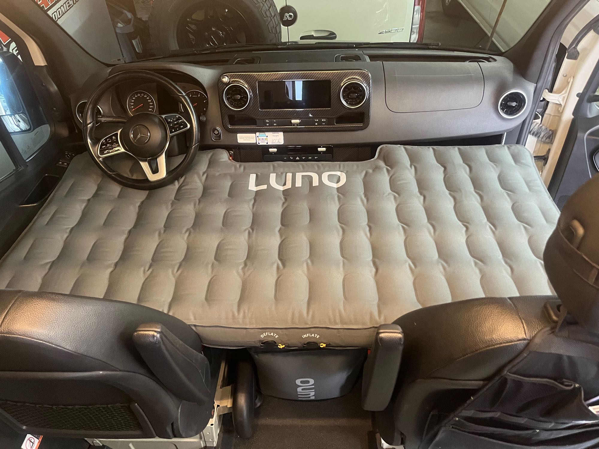 RV rental: Inflated Luno air mattress transforms a Mercedes Sprinter van's front cabin into a cozy sleeping area for travels.. Winnebago Revel 2021