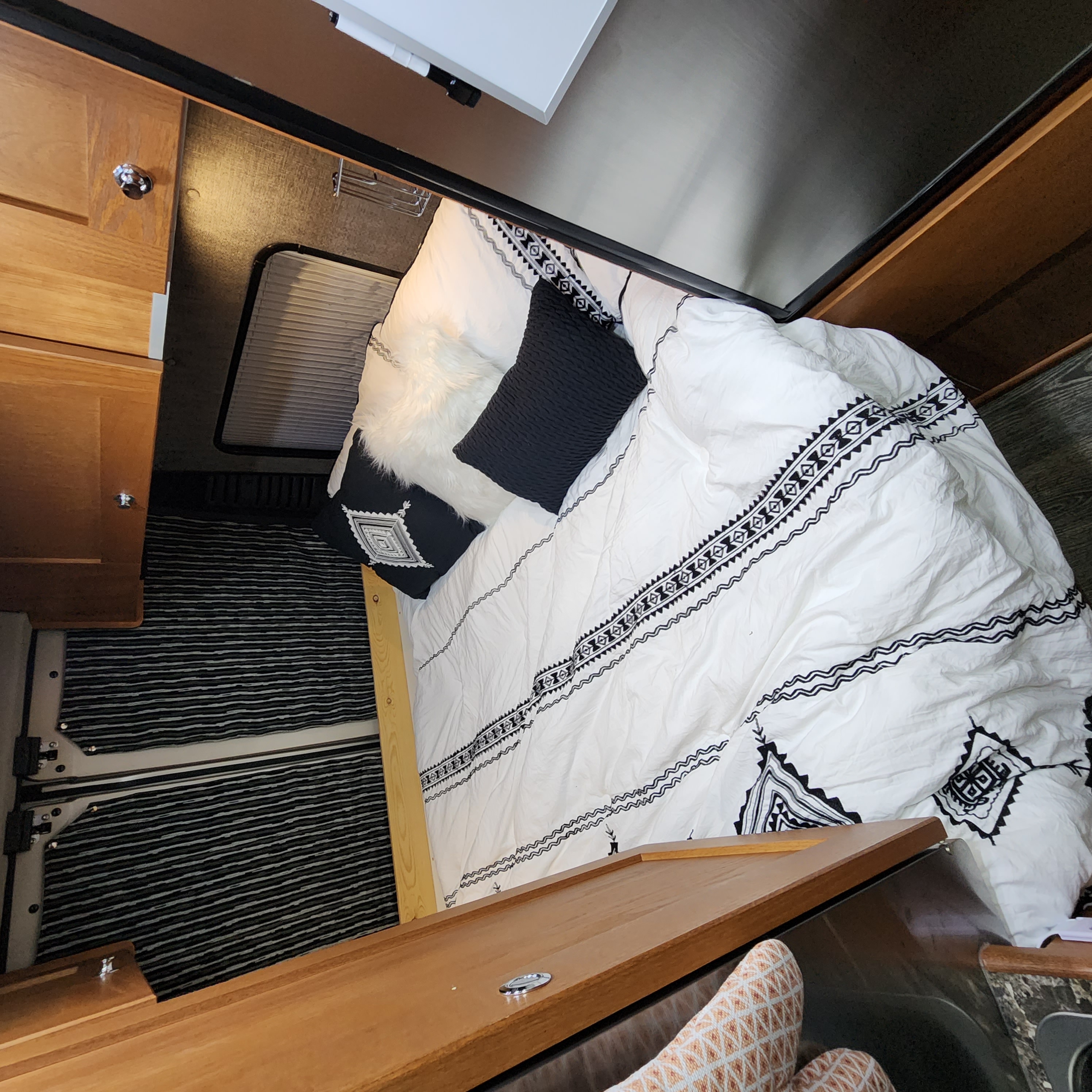 Experience mobile comfort! This RV rental features a cozy bed with stylish geometric bedding & wood cabinetry.. Roadtrek Roadtrek Class B 2017