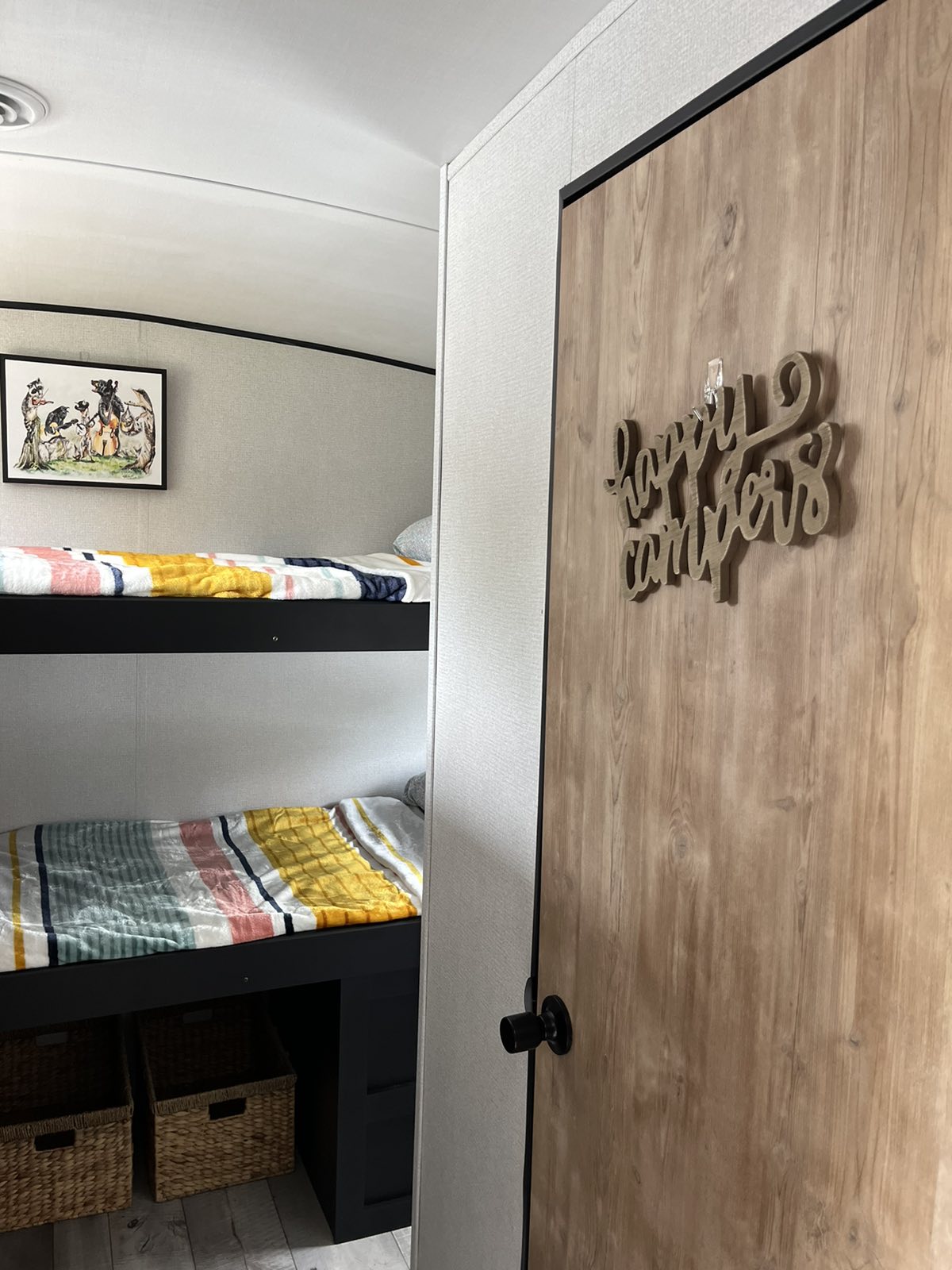 Inside an RV rental: two comfy bunk beds with striped bedding and a playful animal art print, offering a cozy sleeping area.. Keystone RV Springdale 2022
