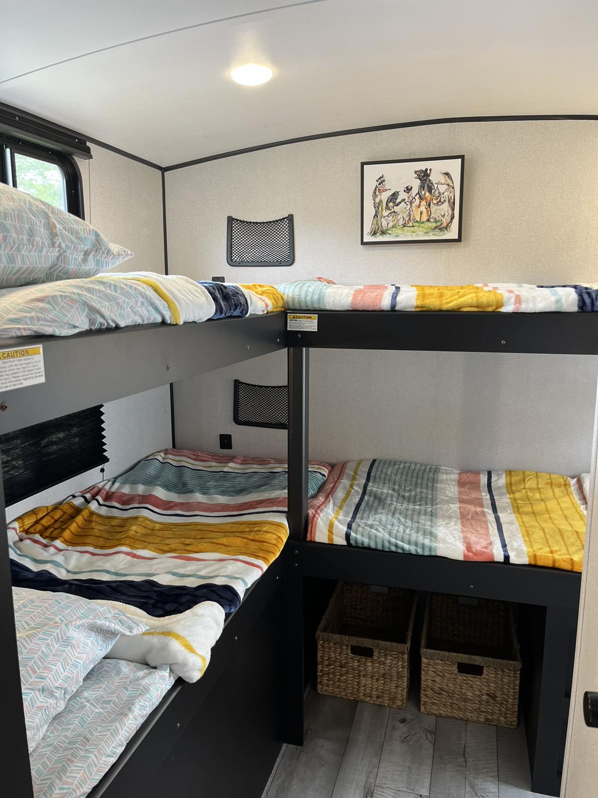 Inside an RV rental: vibrant bunk beds with striped bedding offer cozy sleeping for the whole family during travel.. Keystone RV Springdale 2022
