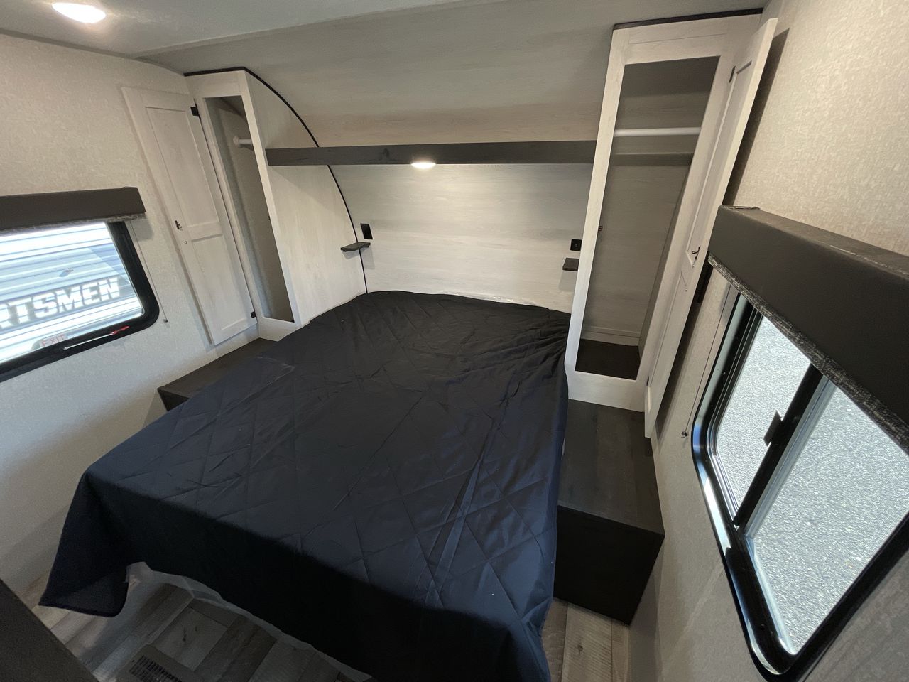 Comfortable RV rental bedroom with dark bed, side wardrobes, and built-in storage for your travels.. KZ Sportsmen SE 260BHSE 2022