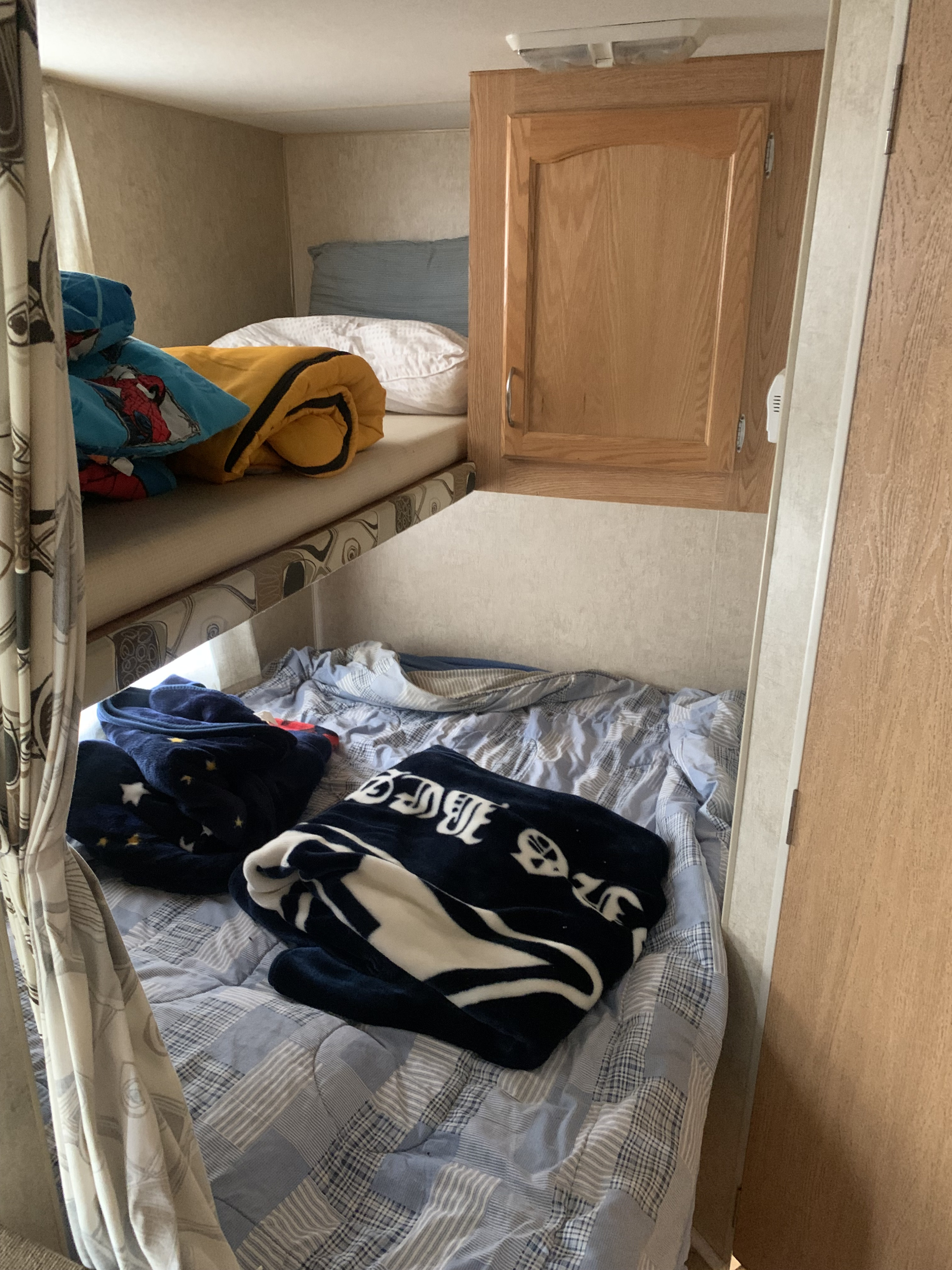 Inside an RV rental: upper and lower bunk beds with soft blankets, offering a comfortable sleeping space.. Fleetwood Mallard 2008