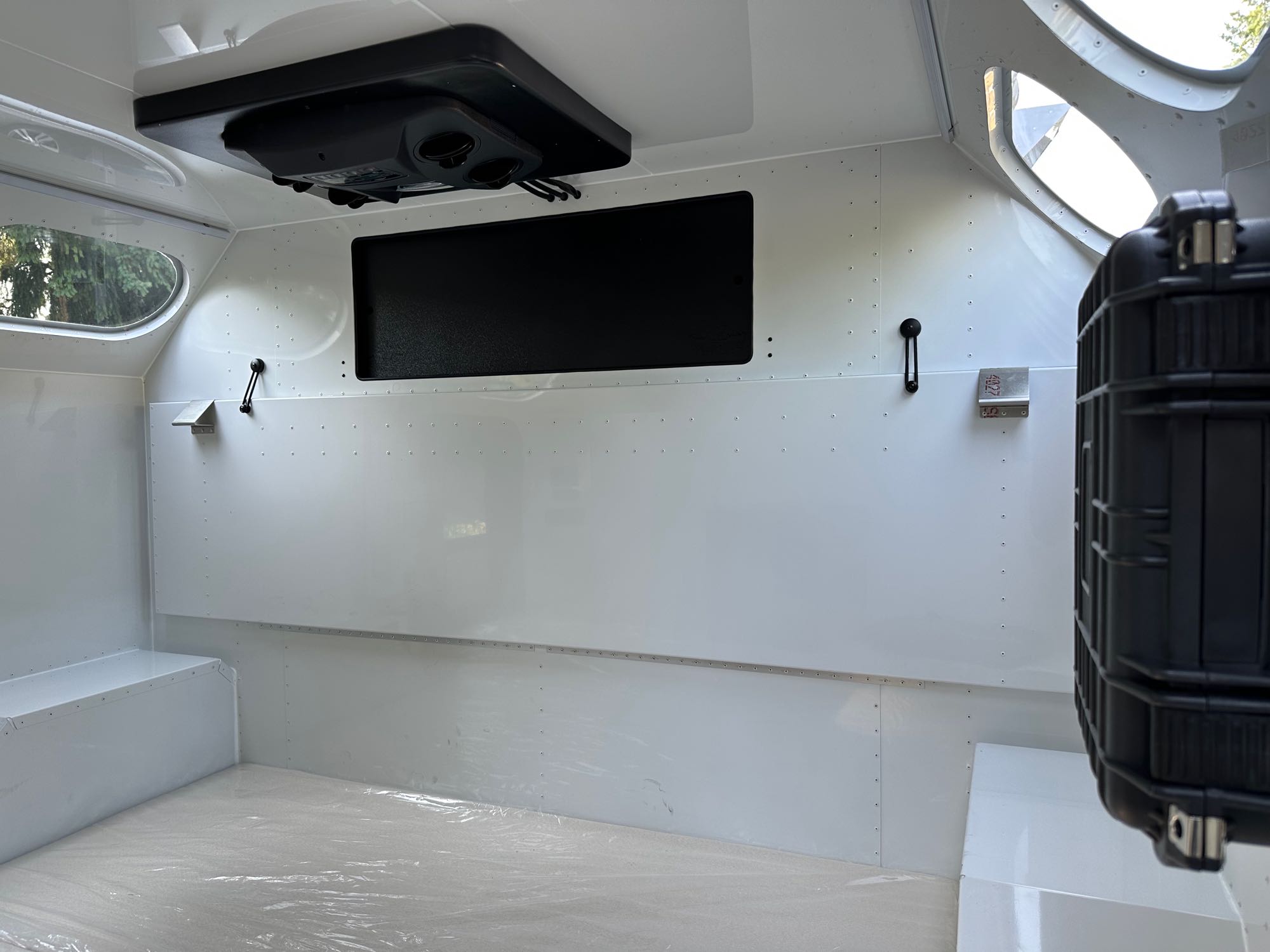 Spacious, white interior of an rv rental, featuring overhead AC, windows, & protective floor covering. Ideal for mobile travel.. Mammoth Overland Mammoth HV 2023