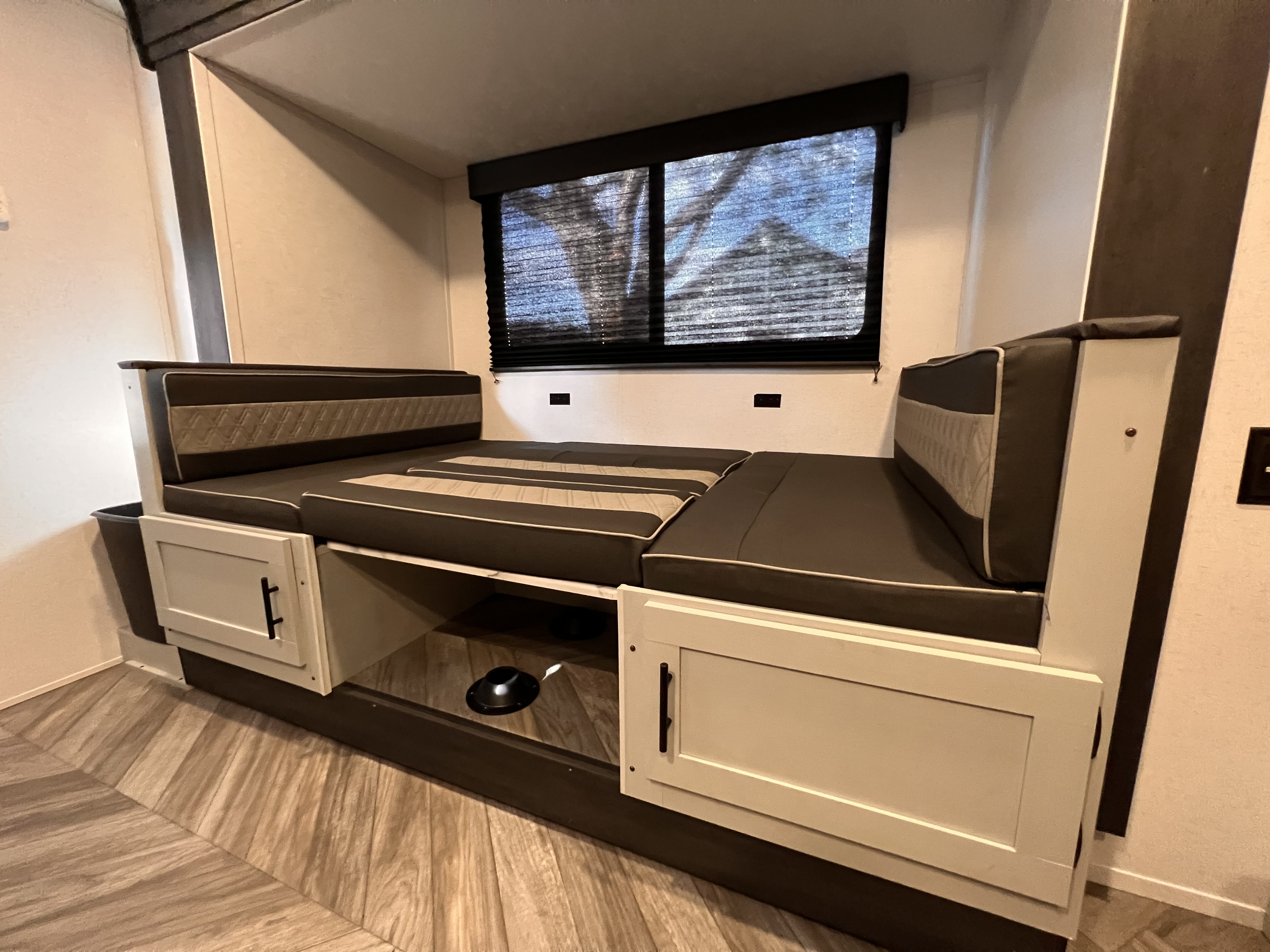 This RV rental's dinette converts into a comfortable bed, featuring storage and a large window.. Forest River Wildwood FSX 2022