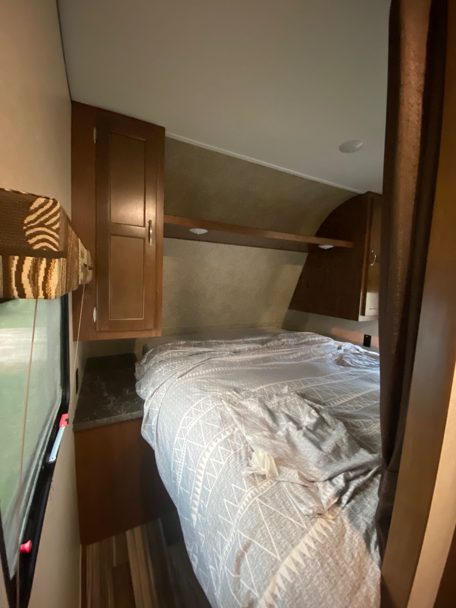 RV rental bedroom: a neat, compact space with a comfortable bed, window, and wooden storage. Ideal travel accommodation.. Jayco Jay Flight SLX 2017