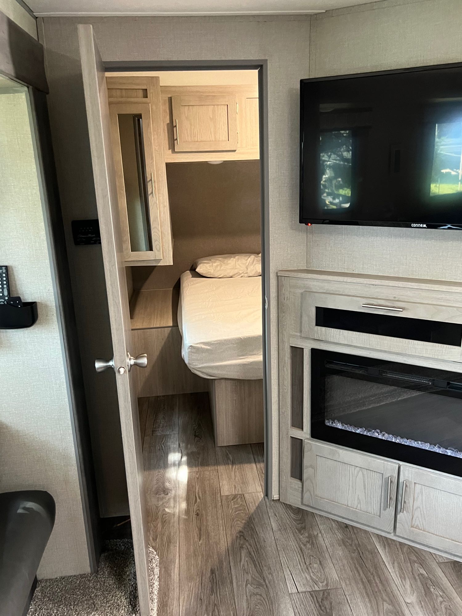 Compact RV rental living area featuring TV, fireplace, and a glimpse into the cozy bedroom.. Forest River Coachmen Catalina Legacy 2022