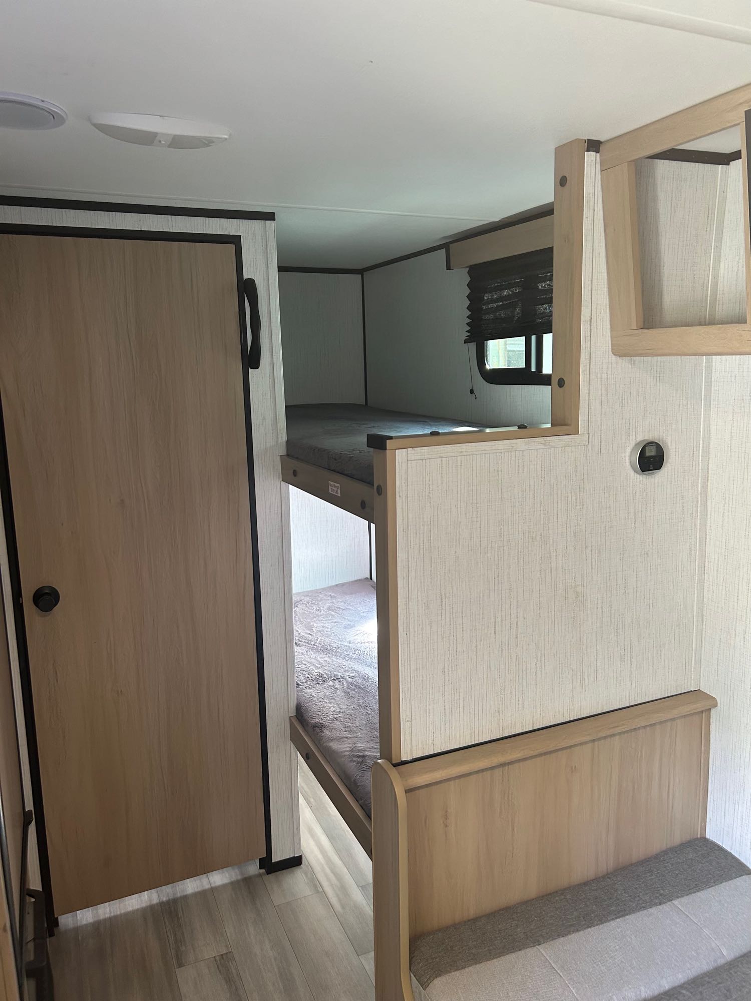 RV rental bunk beds: a clean, modern interior with light wood accents, a window, and a door.. Cruiser RV Hitch 2022