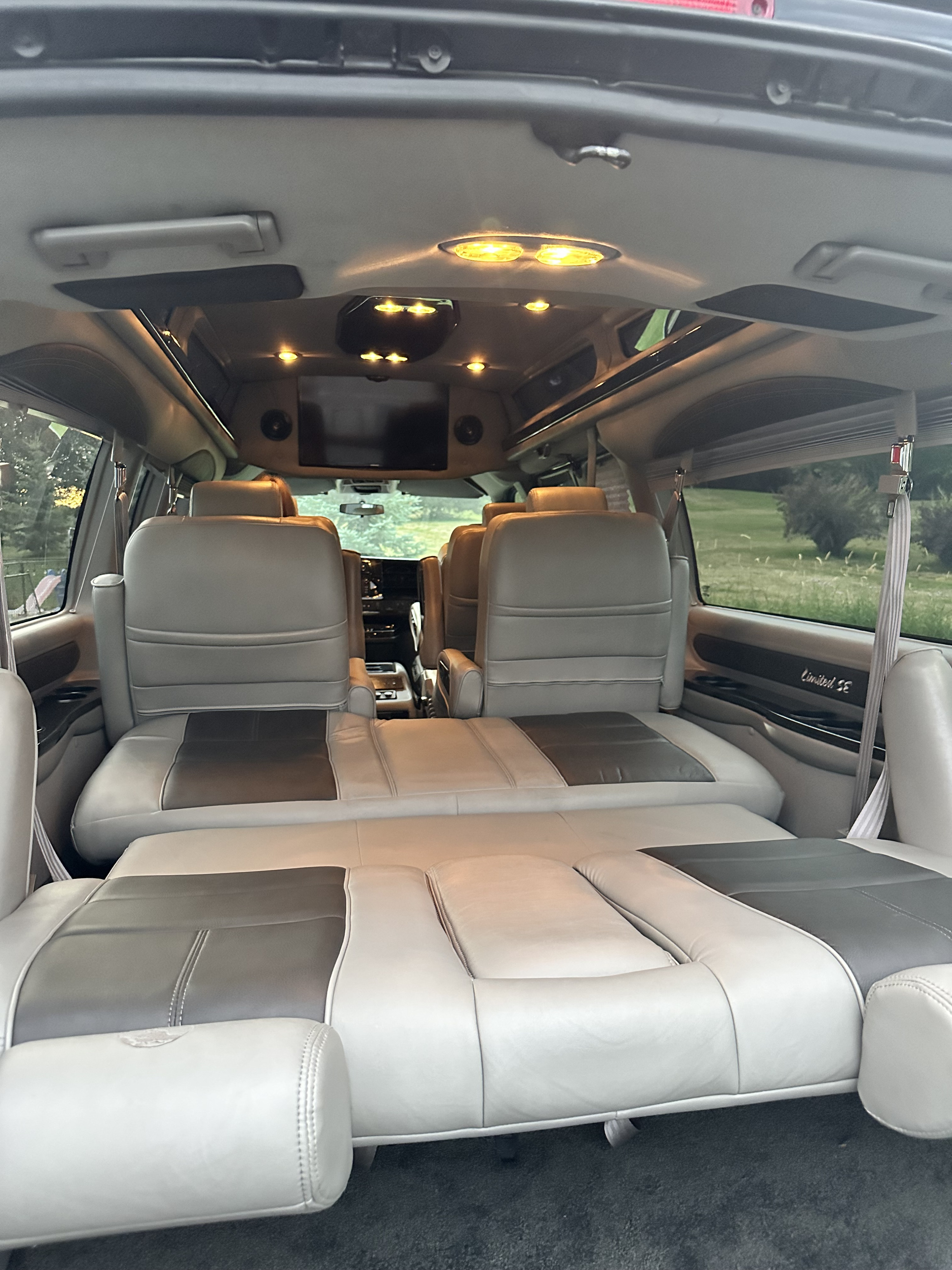 Spacious RV rental interior featuring reclinable seats that convert into a flat bed, overhead TV, and ambient lighting.. Gmc K2500 2017