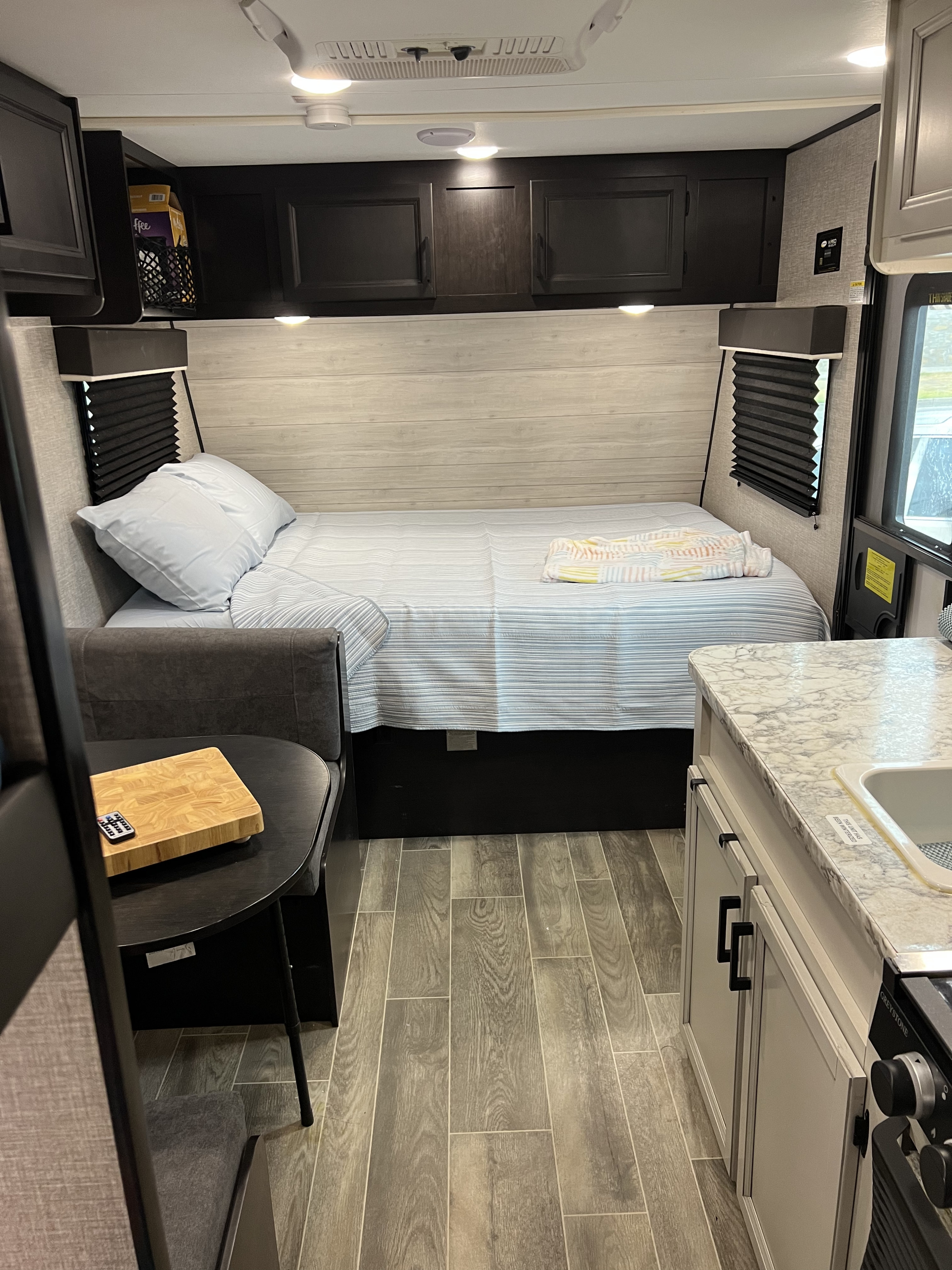 Cozy RV rental interior with a comfortable bed, compact kitchen, and dining area, perfect for travel adventures.. Jayco Jay Flight SLX 2022