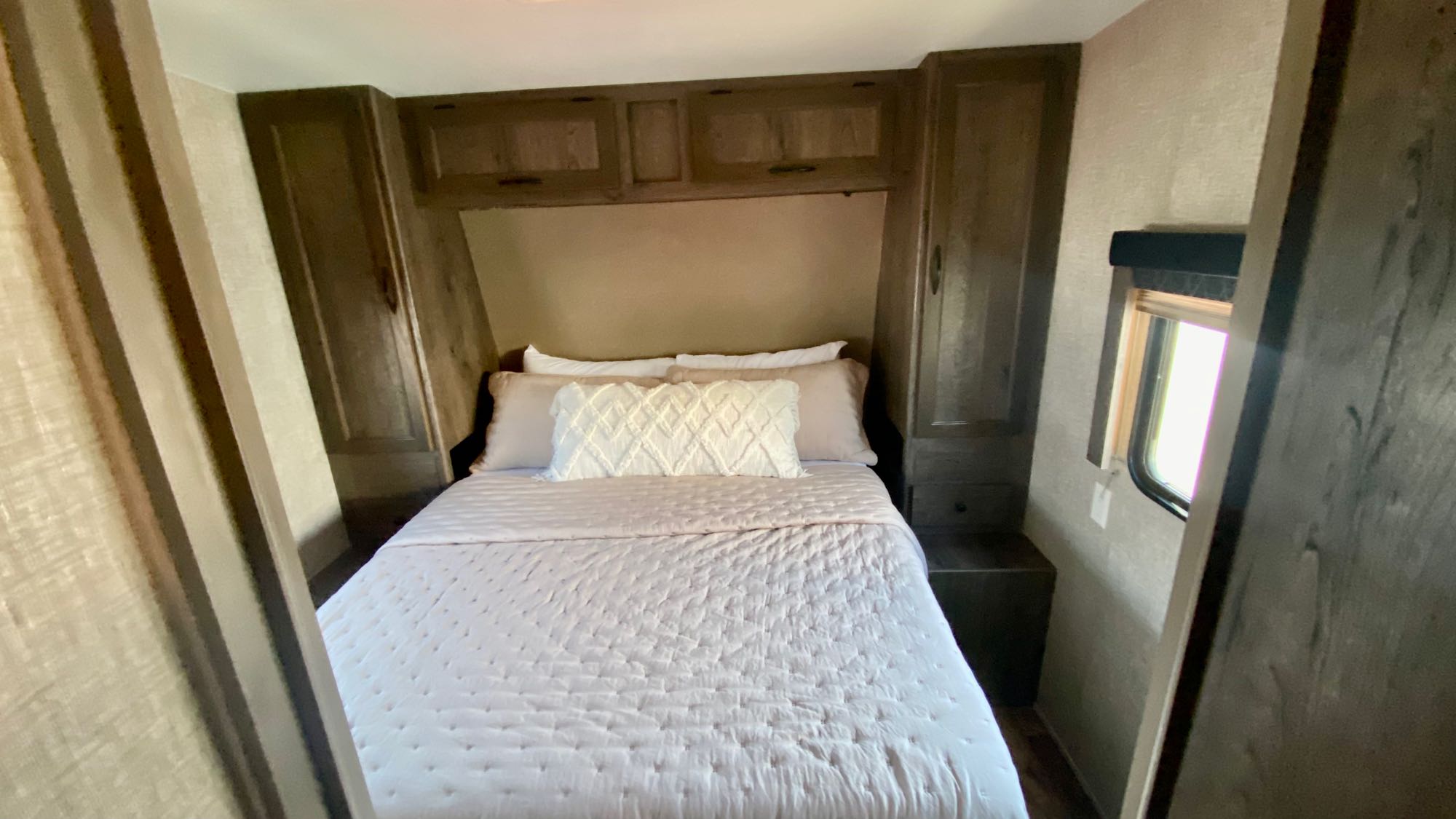 Inviting RV rental bedroom with a comfy bed, wood cabinets, and window. Your cozy retreat on wheels.. Eclipse Recreational Vehicles Attitude 2016