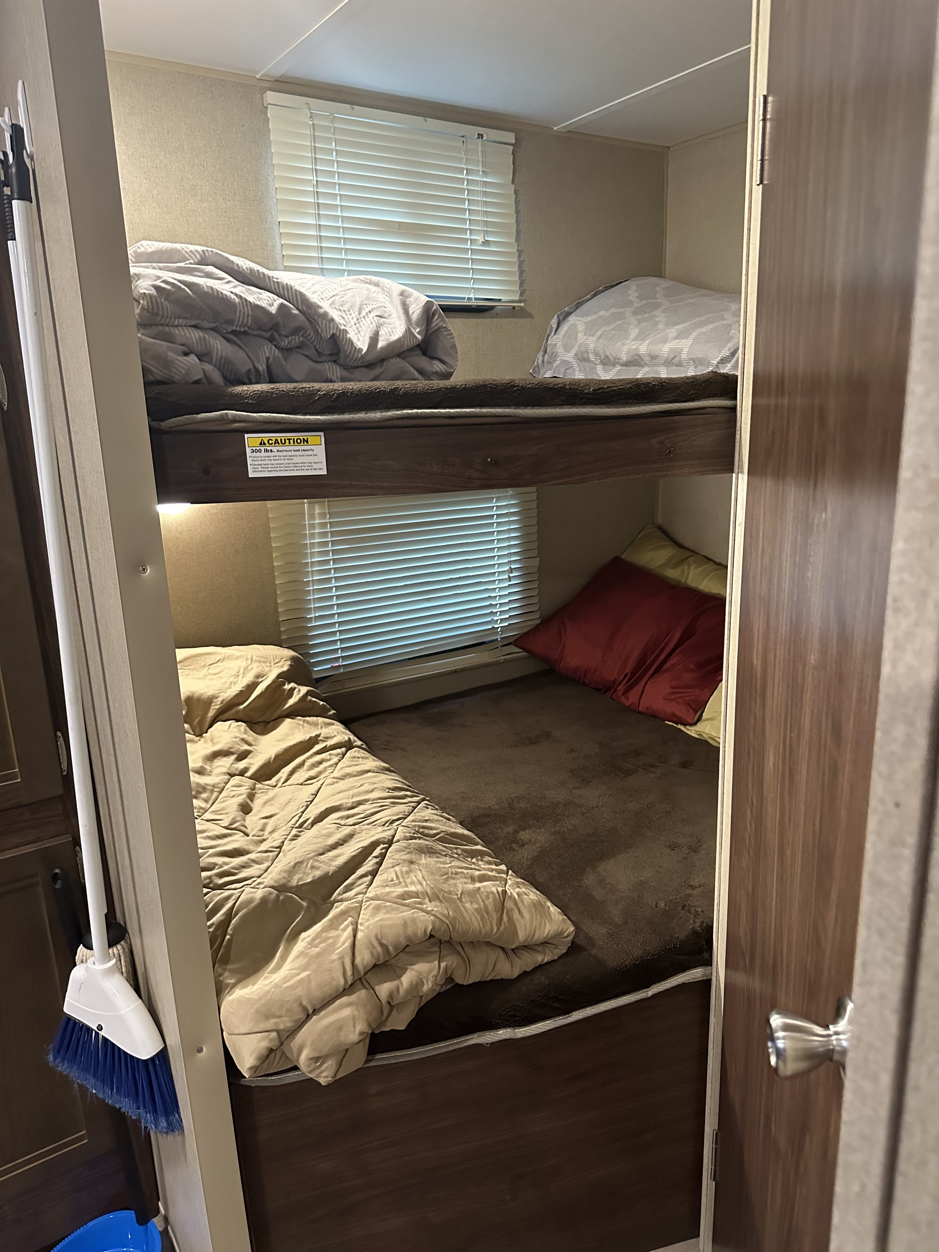 Experience an RV rental with practical bunk beds. Upper and lower bunks, cozy bedding, and windows offer comfortable stays.. Coachmen 264bh 2017