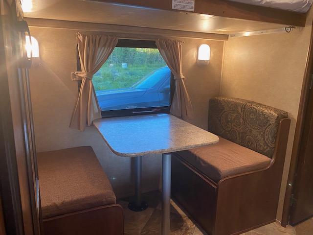 RV rental interior: inviting dinette with cushioned bench seats and table. Perfect for your next road trip adventure.. Crossroads RV Zinger 2014