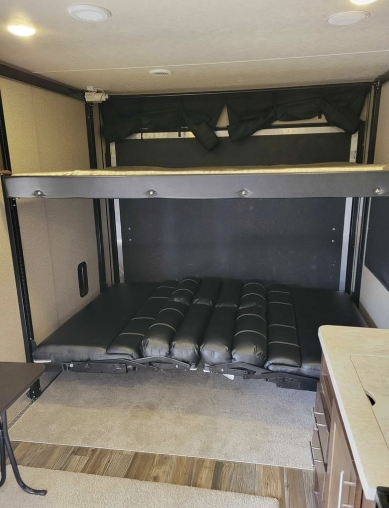 RV rental: Inside a toy hauler, featuring a comfortable bunk bed system with a convertible lower bed.. Forest River Wolf Pack 2016