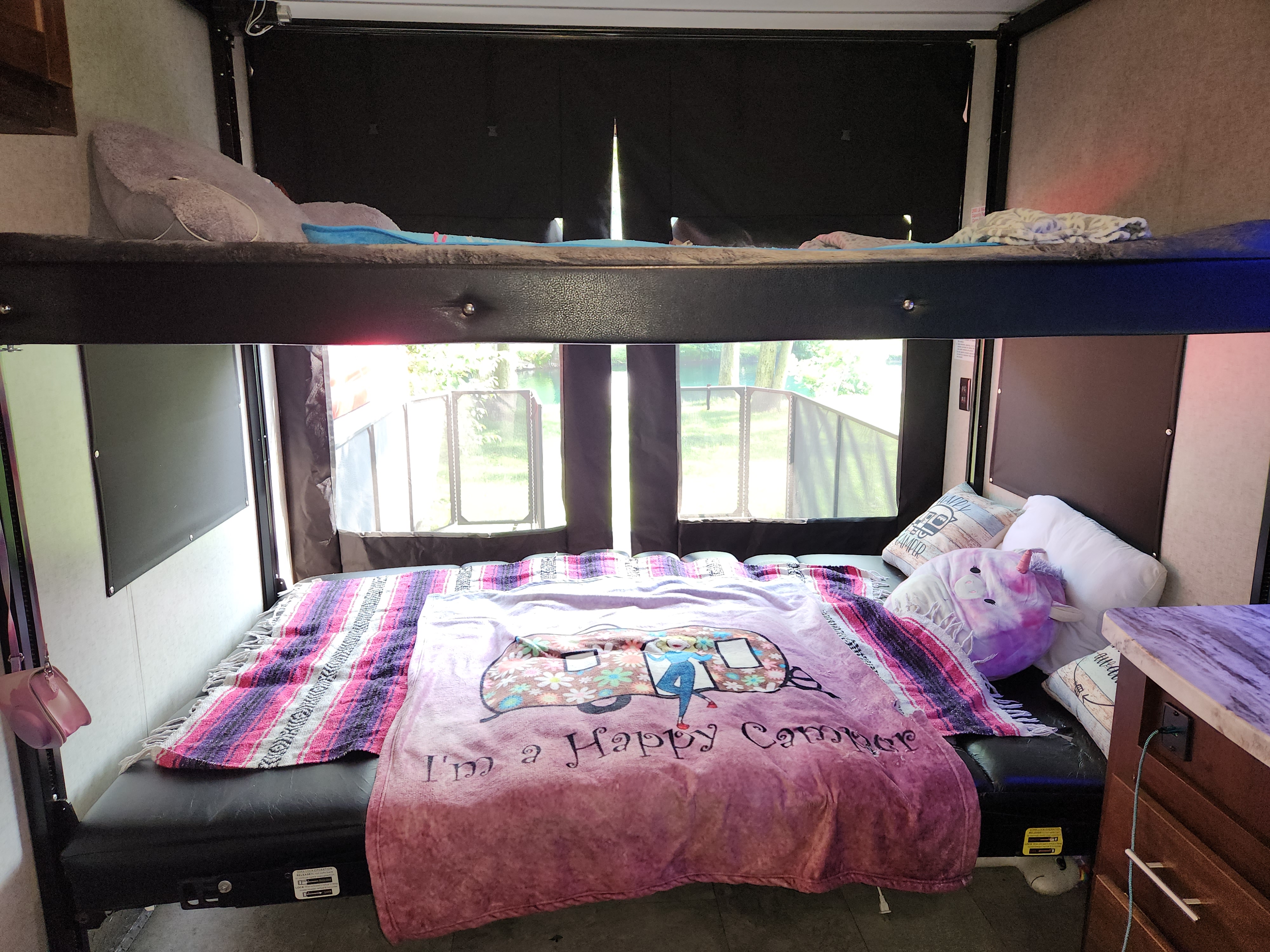 RV rental with versatile sleeping: comfy bunk beds, convertible lower bed with "Happy Camper" blanket, and nature views.. Forest River Vengeance 2019