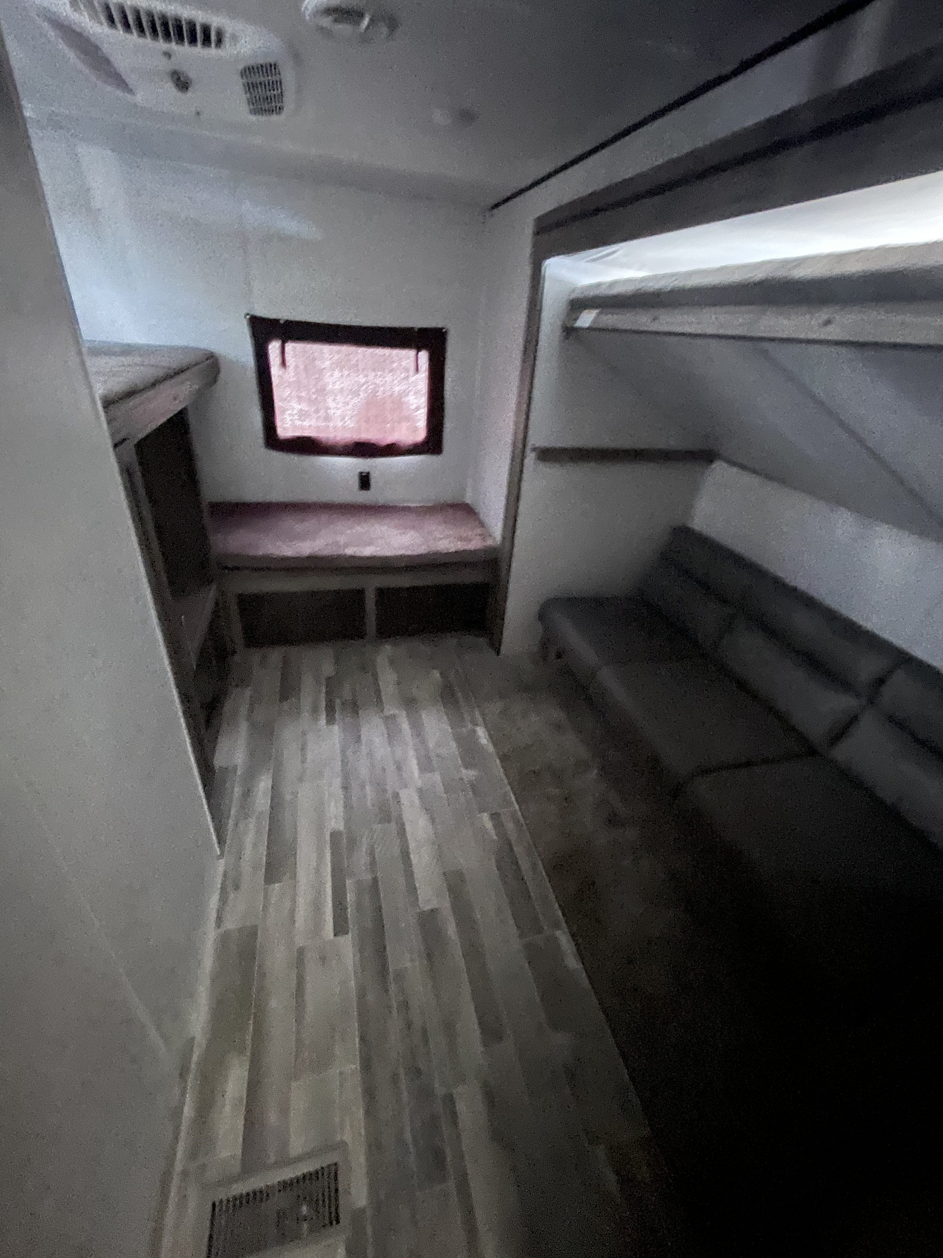 RV rental interior showing bunk beds, bench seating, and wood-look flooring for compact living.. Crossroads RV Zinger 2023