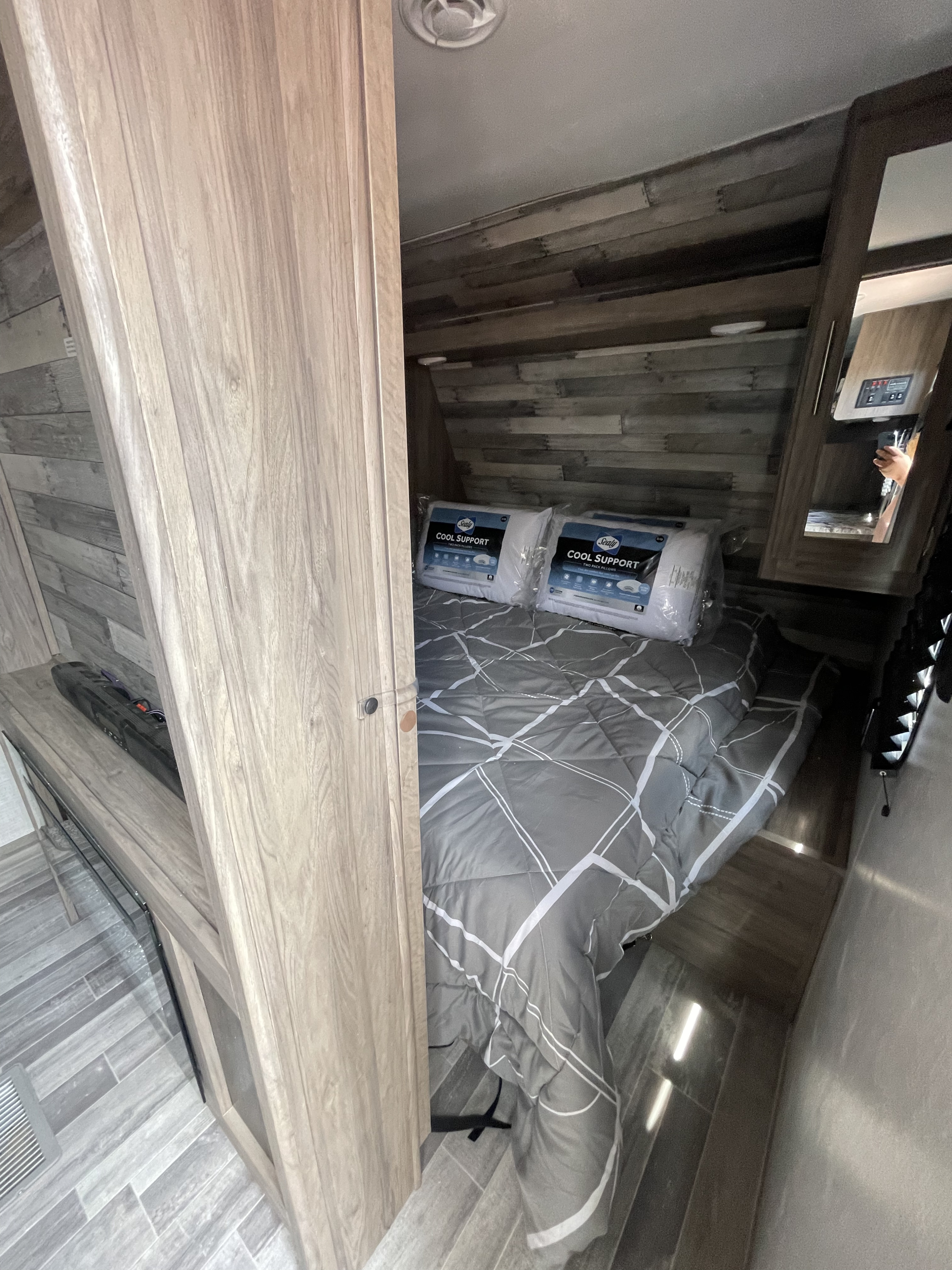 Experience comfort in this RV rental bedroom. Features a bed with patterned comforter & new Sealy Cool Support pillows.. Crossroads RV Zinger 2023