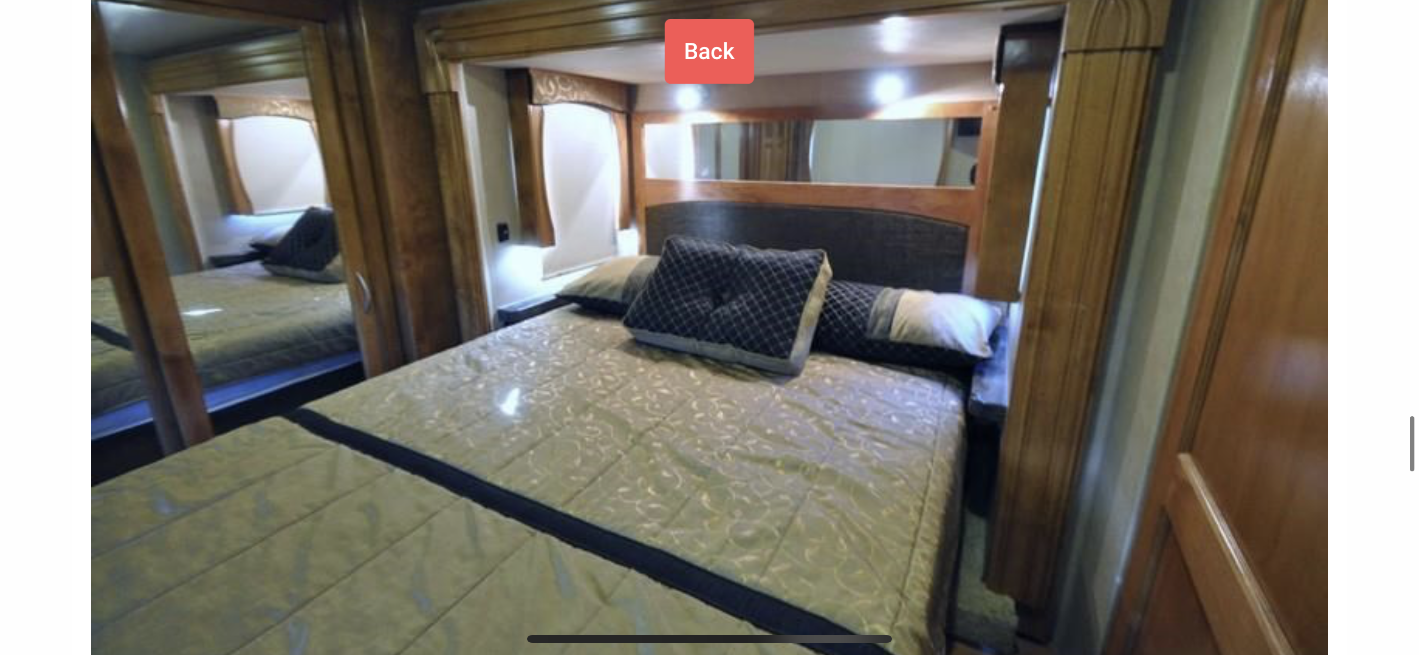Cozy RV rental bedroom with patterned bedding, wood interior, and mirrored closet.. Monaco Vesta 2012