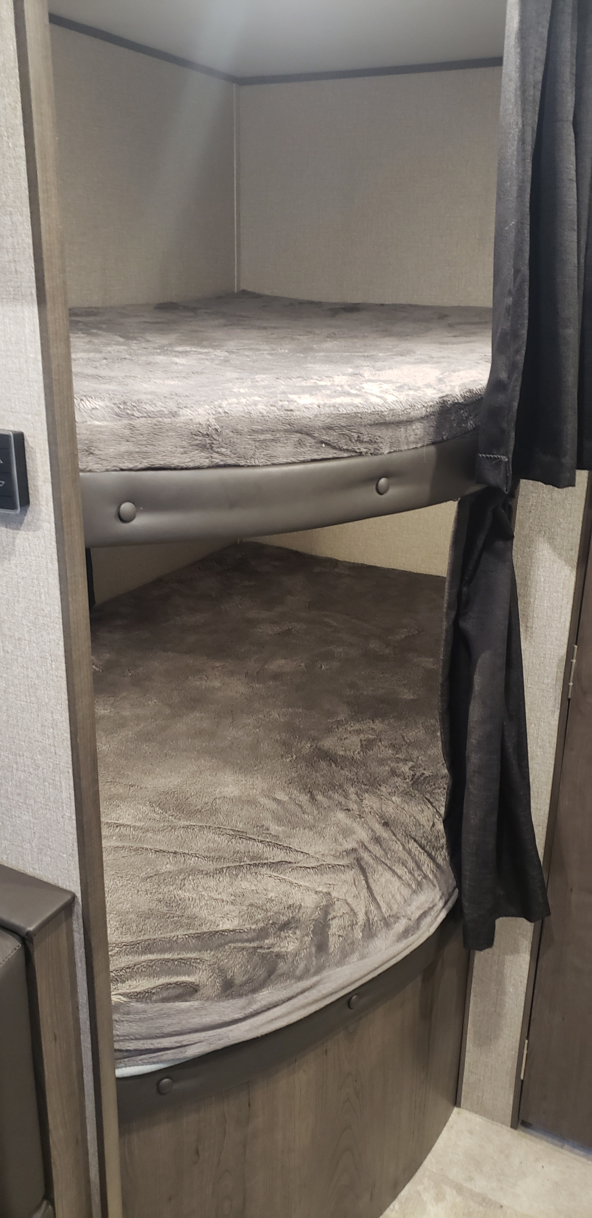 Cozy RV rental bunk beds. Two grey-blanketed bunks in a camper, perfect for family adventures in a travel trailer.. Jayco Jay Flight SLX 2020